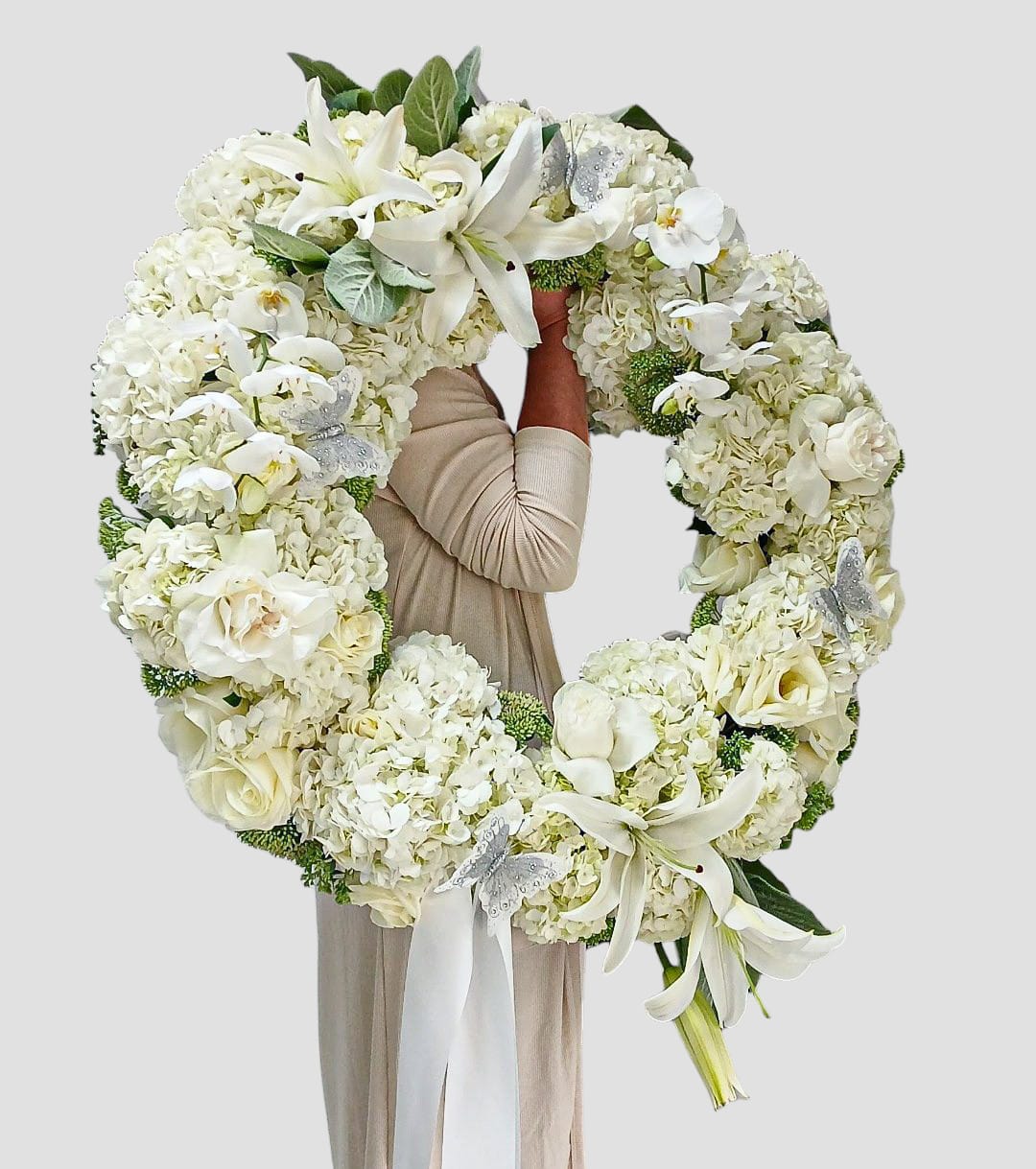 Vanilla Sympathy Wreath Designer's Choice - Send this stunning and elegant grand all vanilla blossoms sympathy wreath filled with roses orchids hydrangeas lilies succulents and so much more adorned with a long white ribbon.  Thoughtful heavenly and perfect to send to the service to show them how much you care. All of my bouquets are always made extra special and unique each time. Send them your deepest condolences.