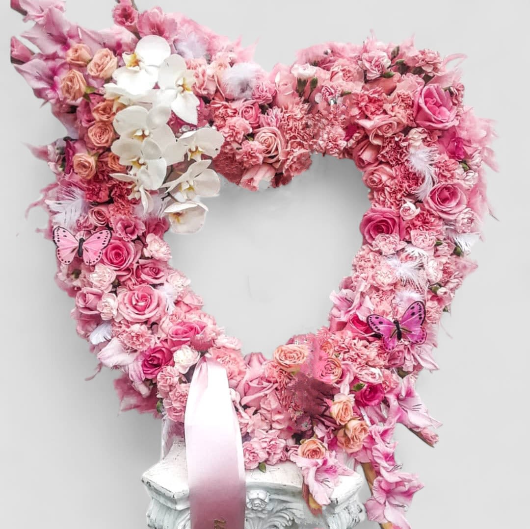 Pink Angel Heart Wreath Designer's choice - Send this beautiful large pink and white angelic heart wreath today to help celebrate a life well lived with it's lovely mix of pink and white blossoms of the day roses orchids and more arranged as a heart tribute flower arrangement. Elegant and loving. Perfect to send today to the service. All of my bouquets are always made extra special and unique each time. Jewelry not included. Help honor them in the most loving way.