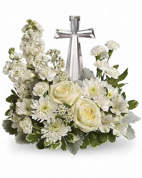 Teleflora's Divine Peace Bouquet - An elegant display of faith and divine peace, this beautiful arrangement will comfort the bereaved in a truly thoughtful and respectful way. An exquisite crystal cross is surrounded by a bed of lovely blossoms. It is sure to be appreciated and always remembered.  A fragrant mix of pure white blooms - including roses, alstroemeria, stock, carnations and waxflower - is accented with dusty miller and variegated pittosporum around an exclusive Crystal Cross keepsake