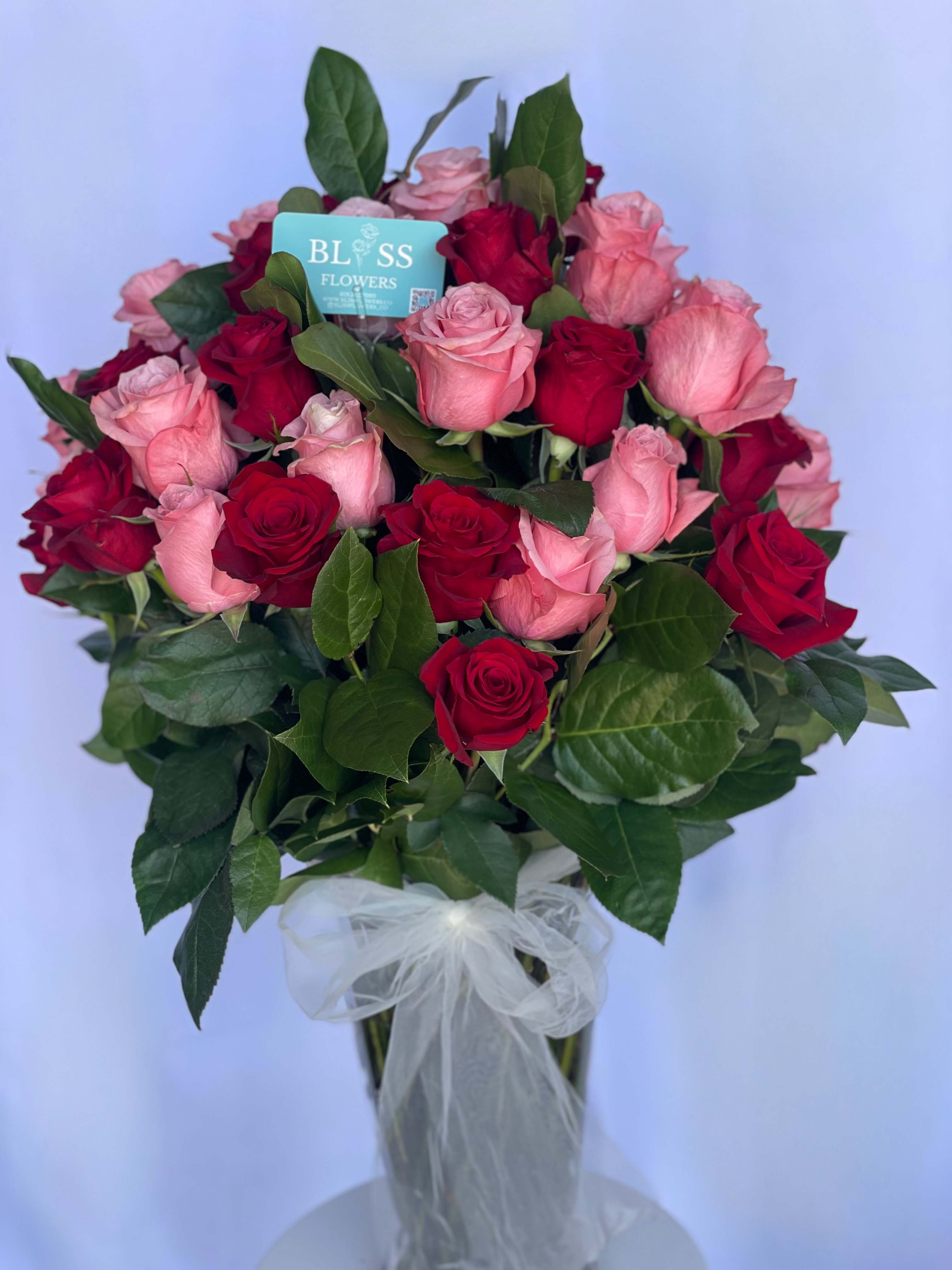 Scarlet petal dream Scarlet petal dream - Dreamy and bold, scarlet petal dream roses showcase a mesmerizing blend of pink and red. Perfect for expressing heartfelt emotions. Arrangement consist of 25 pink with 25 red roses and greenery in a vase.