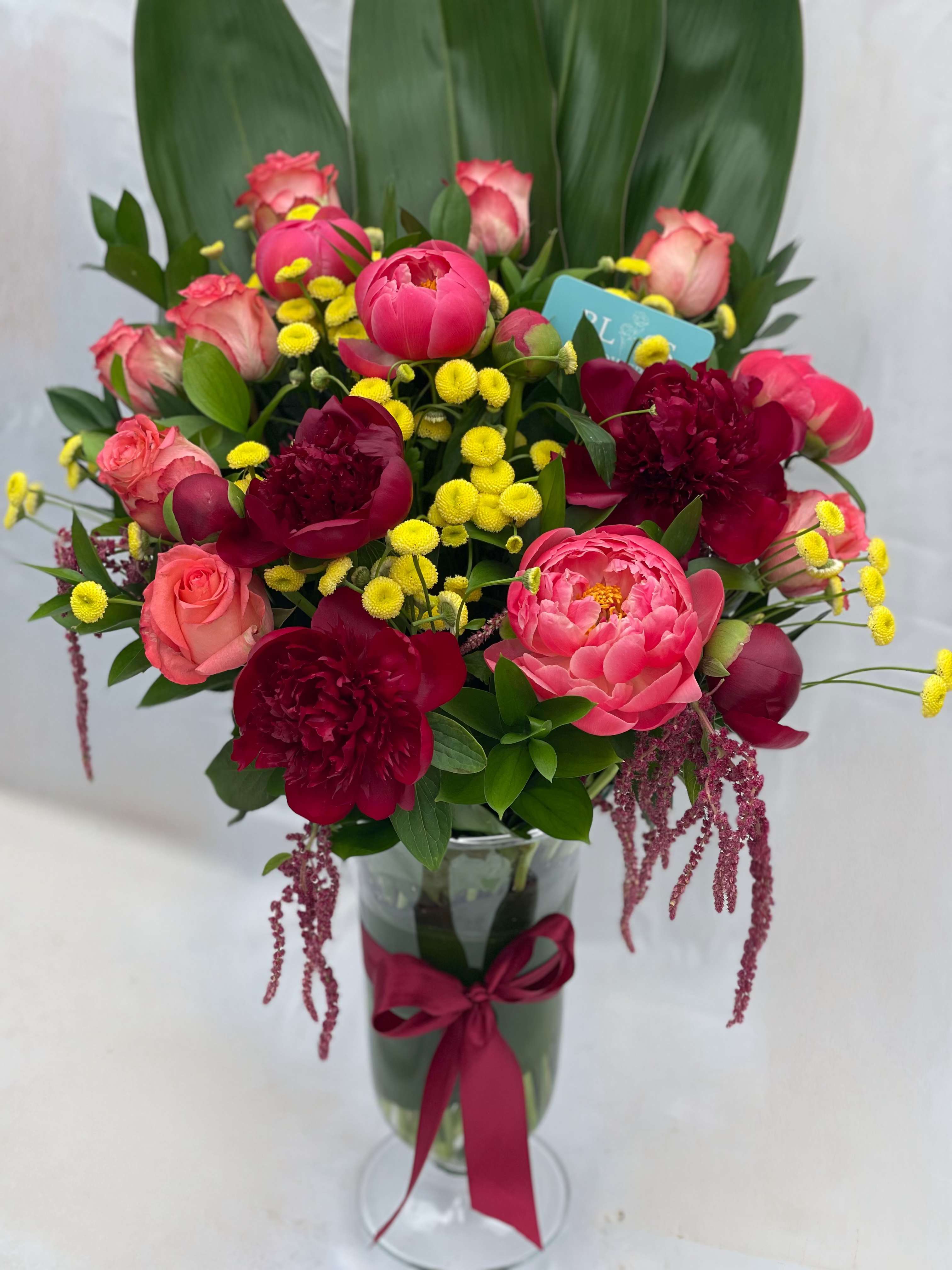 Vibrant Bliss Peonies Vibrant Bliss Peonies - Celebrate with a burst of color and cheer -- this vibrant arrangement of roses, peonies, and yellow fillers in a lovely vase is perfect for making any special occasion unforgettable.
