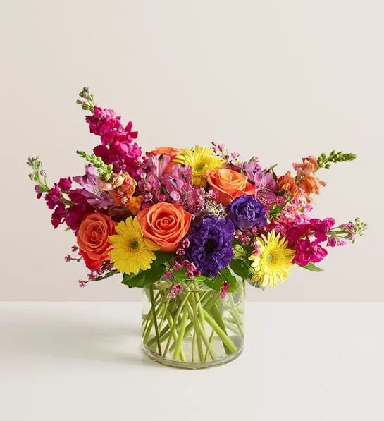 Vivid Beauty  Bouquet -  special bouquet for a truly special person. With its bright colors—orange, purple, yellow, fuchsia—and eye-catching crescent silhouette, this arrangement is as dazzling as it is memorable. It’s a spectacular way to brighten someone’s home as well as their day.