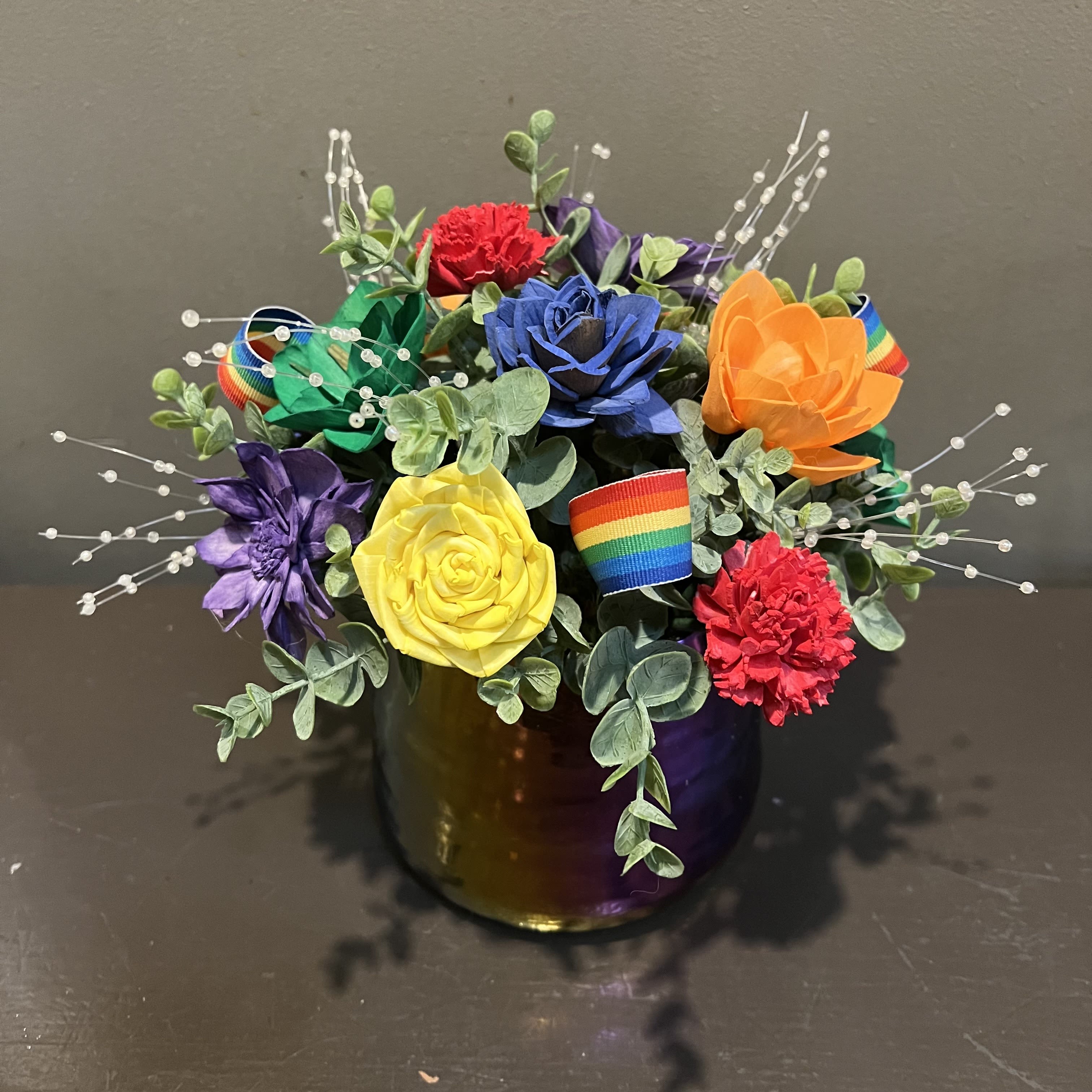 Sola Wooden Flower Centerpiece - Rainbow Pride Sola Wooden Flower Centerpiece - Rainbow Pride - Hand-crafted in Minneapolis, these flowers made of balsa wood are a wonderful everlasting floral arrangement - great for those with allergies! Can be used as a natural essential oil diffuser too! Arrives in a keepsake ceramic vase. Approx. Dimensions: 10"Tx9"W