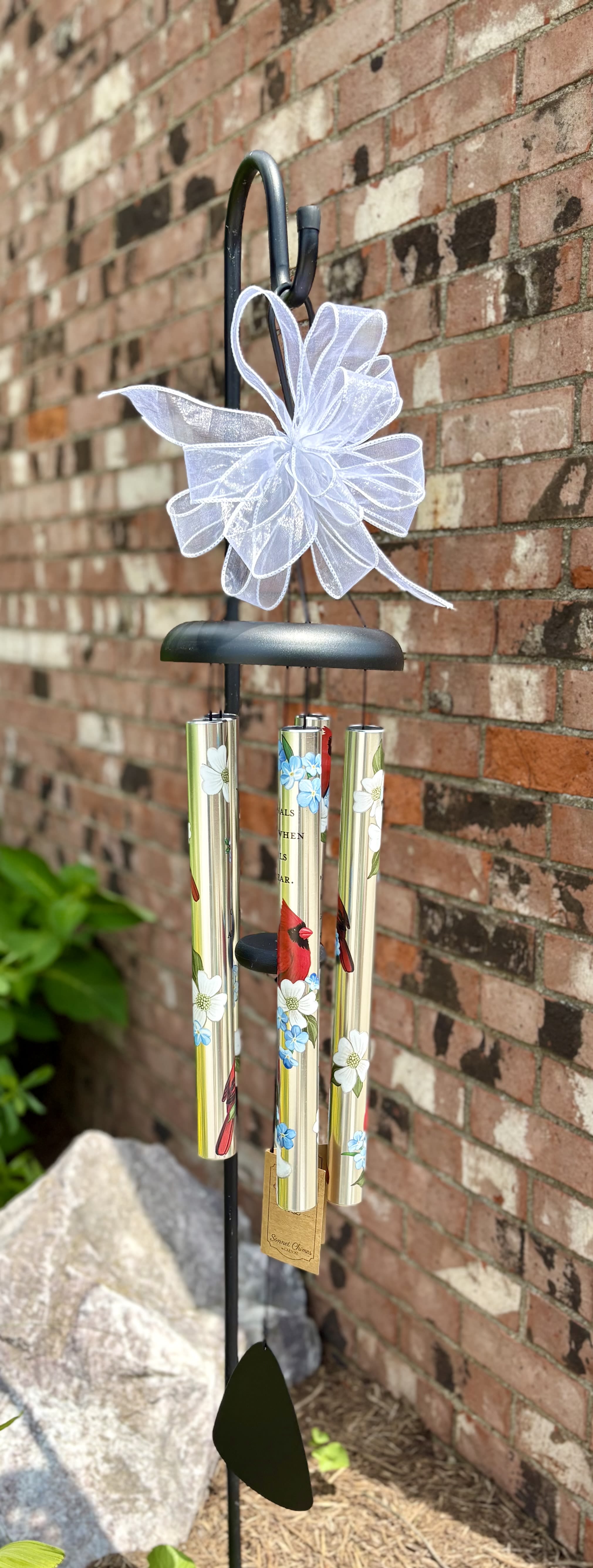 &quot;Cardinals Appear&quot; 38&quot; Wind Chime - Crafted with shimmering metal tubes and tuned to produce soft, comforting tones, this wind chime features the beloved sentiment:  “Cardinals appear when angels are near.”  A perfect sympathy gift or lasting tribute for gardens, porches, or remembrance spaces, this wind chime is a touching way to keep the spirit of a loved one close.  Product Highlights: 	•	Design: Beautiful cardinal and floral artwork on all four tubes 	•	Sentiment: Uplifting message of hope and remembrance 	•	Material: Durable, weather-resistant aluminum with polished finish 	•	Length: Approximately 38 inches 	•	Gift-Ready: Comes with a complimentary bow for a presentation-ready finish  Let every breeze be a moment of comfort, every chime a loving memory.