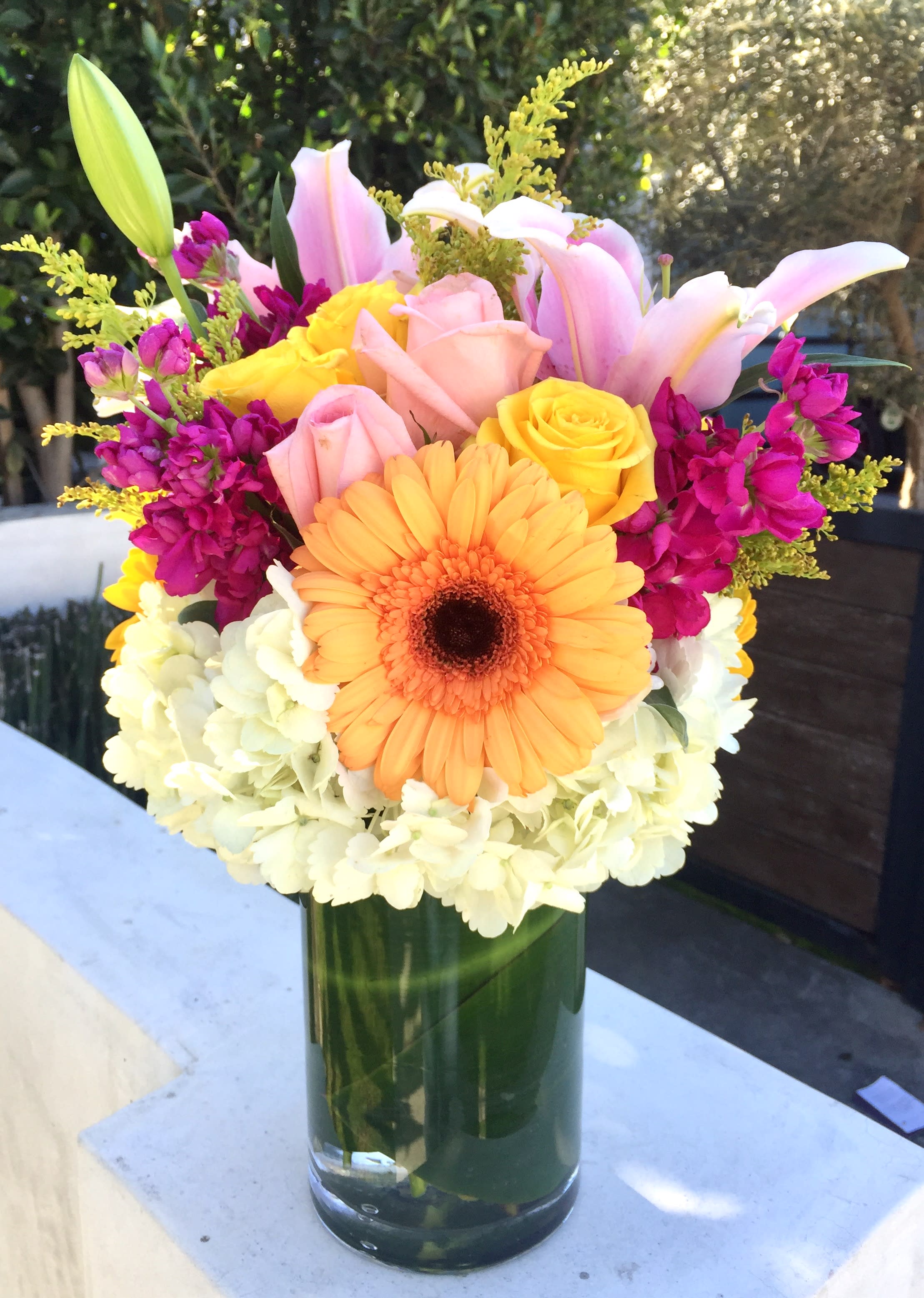 A Lovely Surprise - Send your loved one a surprise today with these colorful and bright bouquet with fresh cut roses, gerbera daisies, hydrangeas, stargazer lilies and stock arranged in a keepsake cylinder vase. Designed for all occasions!  Approximately 16&quot; H x 10&quot; W