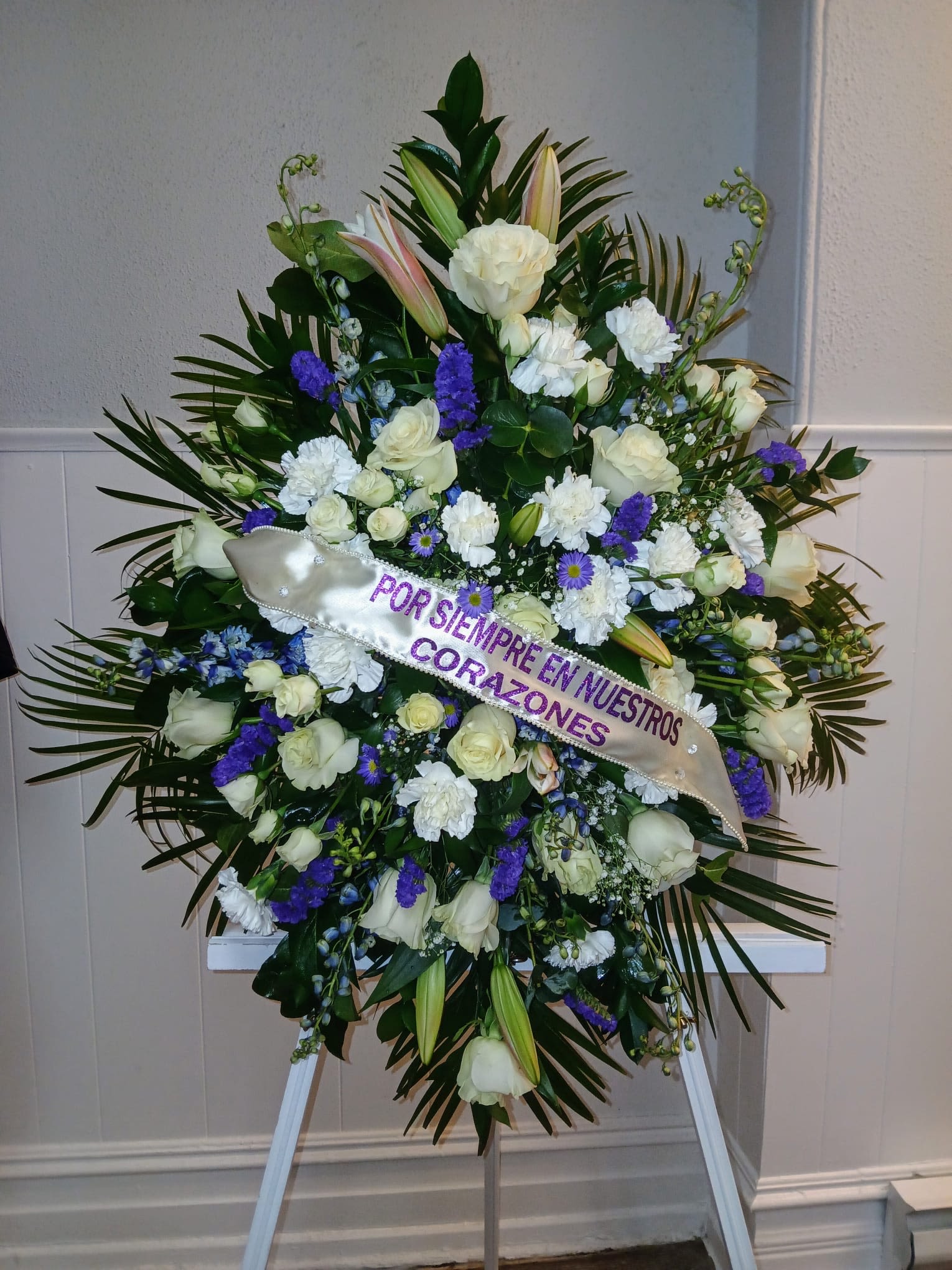 WHITE FUNERAL ARRANGEMENT WITH PURPLE TOUCHES - WHITE FUNERAL ARRANGEMENT WITH PURPLE TOUCHES, (YOU CAN CHOOSE THE COLOR OF YOUR PREFERENCE) COMES ON A GREEN METAL BASE