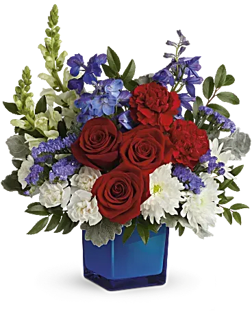 Red White and Blooms - The classic color trio looks more beautiful than ever in this lush rose bouquet, accented with cool, cobalt glass cube. This red, white, and blue arrangement includes red roses, red carnations, miniature white carnations, blue delphinium, white snapdragons, white cushion spray chrysanthemums, blue statice, and greens.