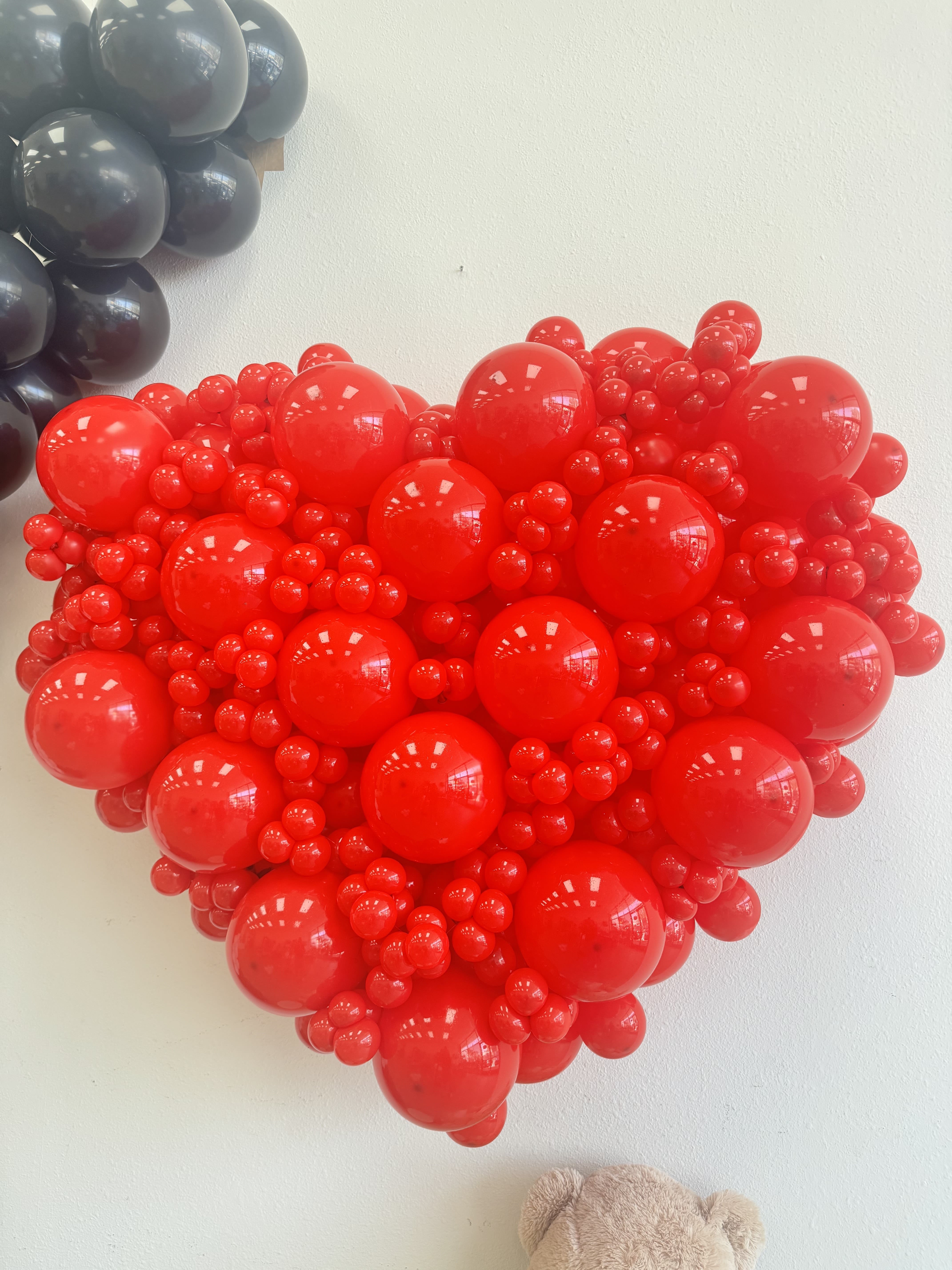 love-themed balloon arrangement - Create a bold and unforgettable statement with our handcrafted Red Heart Balloon Wall — a stunning piece of decor perfect for romantic celebrations, proposals, weddings, bridal showers, anniversaries, or Valentine's Day events. Designed with premium-quality balloons in a rich red palette, this heart-shaped installation adds depth, texture, and a dramatic focal point to any space.  Whether you're planning a luxury event in Los Angeles or looking to surprise someone special, this balloon art offers a modern, Instagram-worthy backdrop that elevates the entire atmosphere.