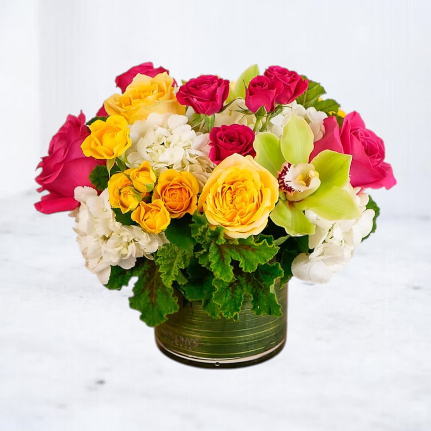 Tang Pop - Unapologetically bold and bursting with personality, Tang Pop is a modern floral statement piece that brings instant energy to any room. Featuring hot pink roses, golden yellow spray and garden roses, crisp white hydrangea, and a striking green cymbidium orchid, this compact design radiates joy and playful luxury. Arranged in a sleek glass cylinder, it’s the perfect pick for birthdays, celebrations, or anyone who deserves a color-fueled surprise.  
