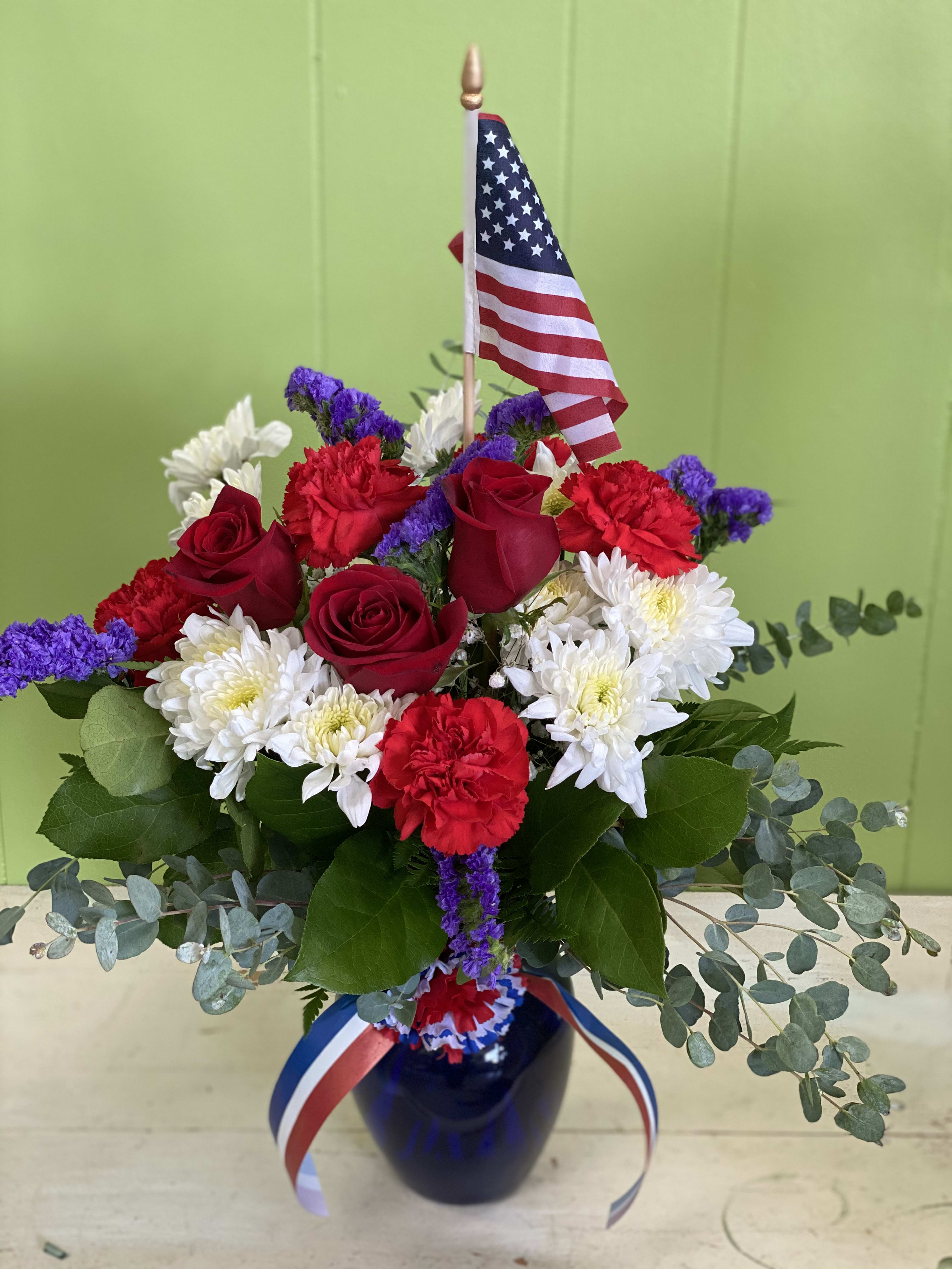 Proud To Be American! Proud To Be American! - If you’re proud to be an American, you’ll surely love this beautiful arrangement of red, white and blue including roses, mums, carnations accent flowers with a keepsake Flag!