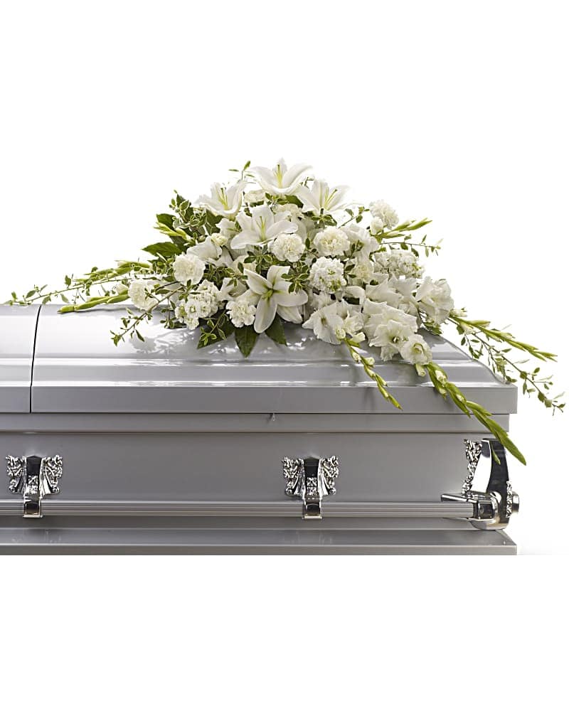 Bountiful Memories Casket Spray Bountiful Memories Casket Spray - Matching luminous all white flowers and delicate garden greenery is an elegantly simple way to lend serenity and quiet strength to the bereaved during a time of great reflection, and pay tribute to the deceased with affection and grace. Flowers such as pure white oriental lilies, gladioli, carnations and stock blend with fragrant greens to create a beautiful crescent-shaped half-casket spray.