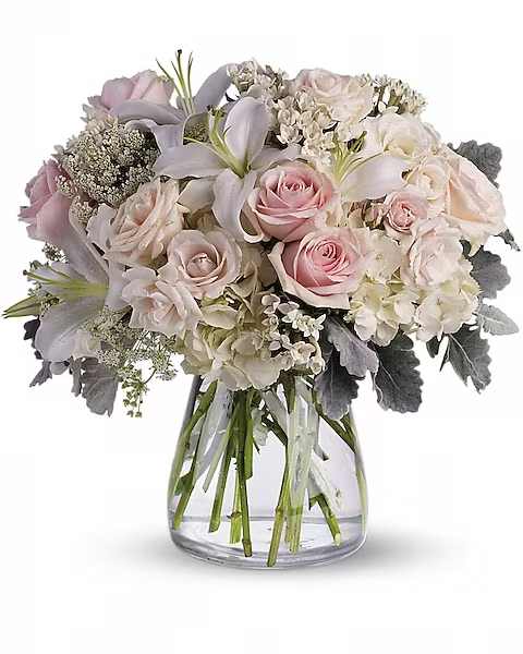 Beautiful Whisper - A whisper-quiet affirmation of love. Subtle shadings of pink and white roses, lilies and delicate Queen Anne's lace in a simple, elegant vase.  Gorgeous flowers such as white, crème and light pink roses, white oriental lilies and delicate Queen Anne's lace with a touch of silvery dusty miller, all in a classic hurricane vase.