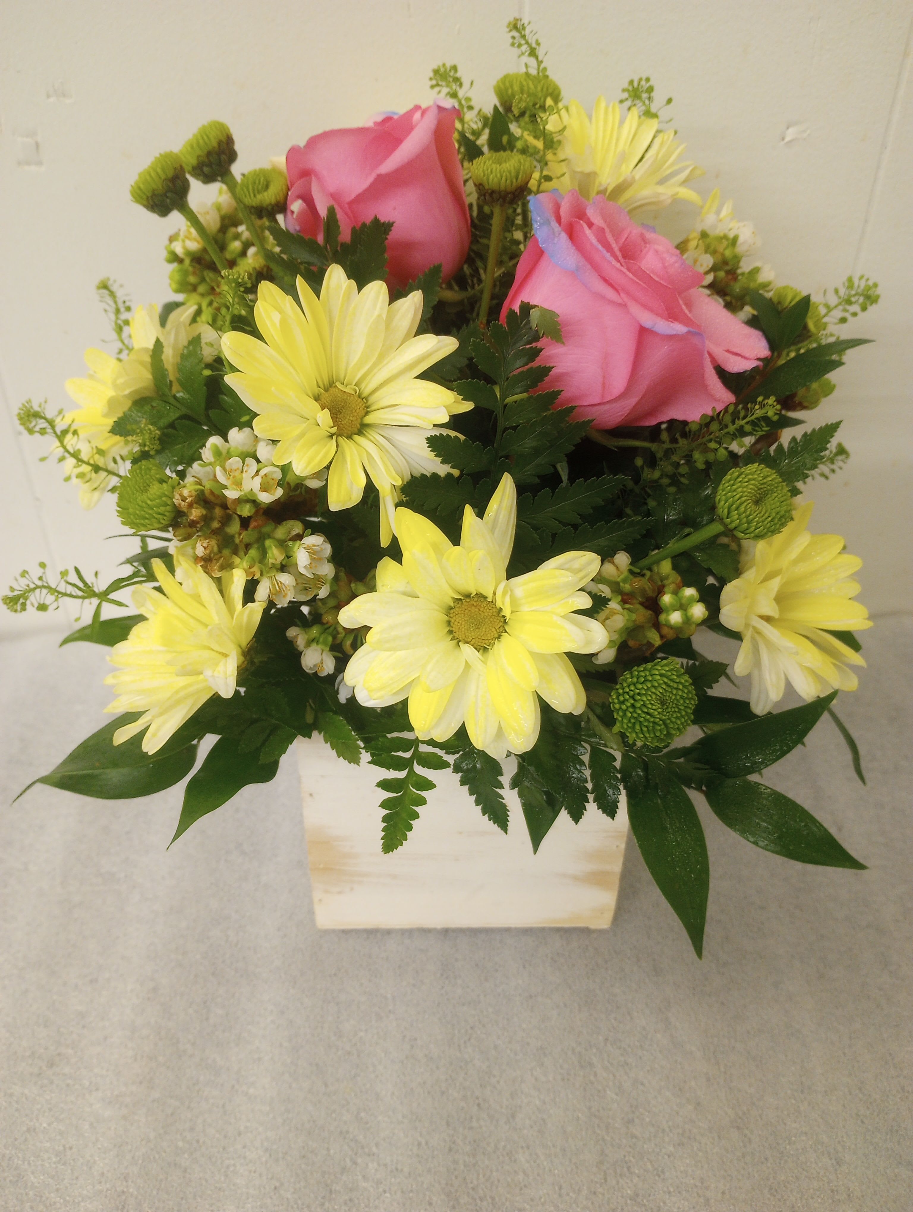 Be Joyful  - Roses, daisies and buttons mums, together in a whitewashed wooden box with seasonal greens.