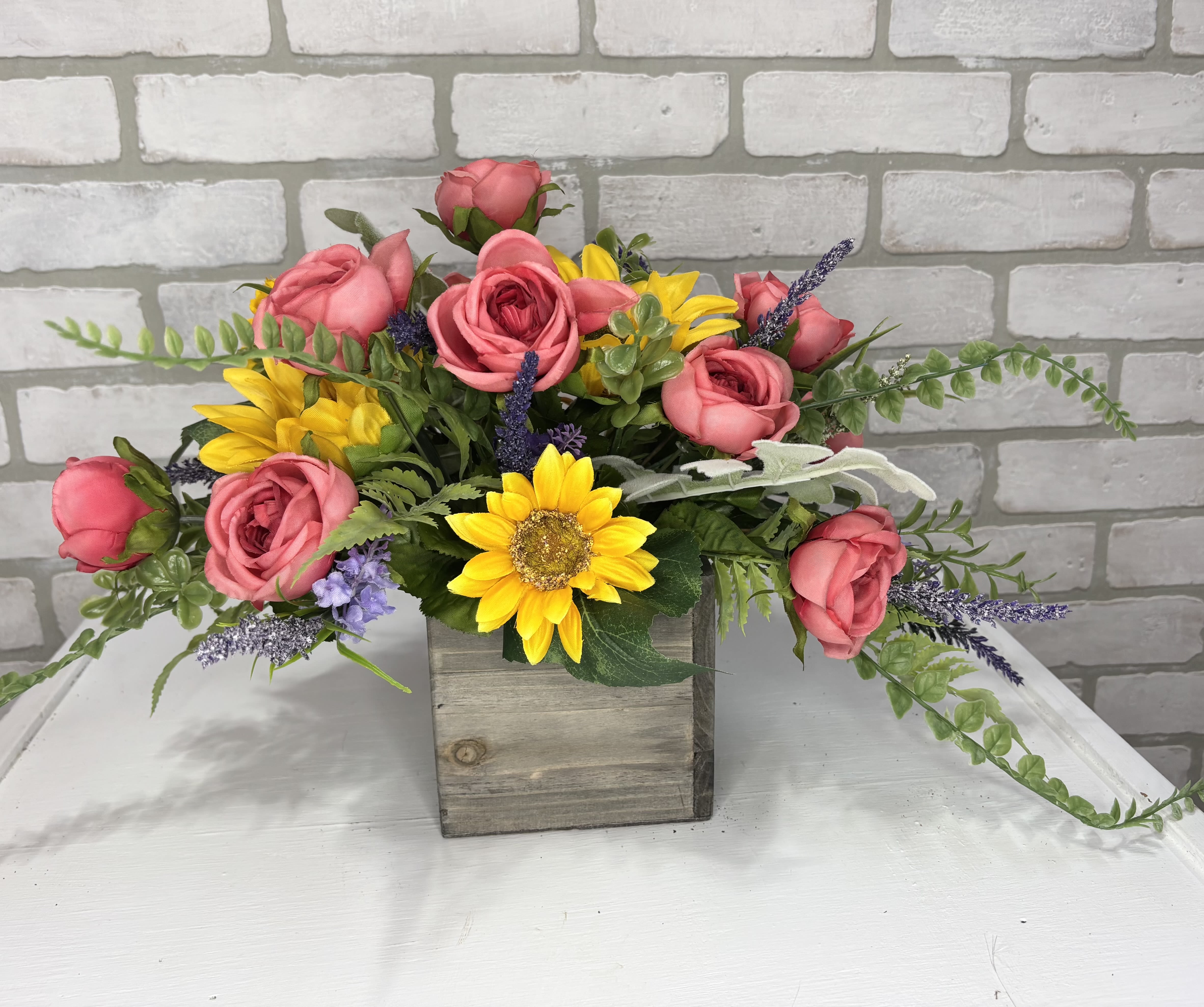 Ranunculus &amp; Sunflower Silk Arrangement - A wooden box arranged with artificial ranunculus, sunflowers, and greens.