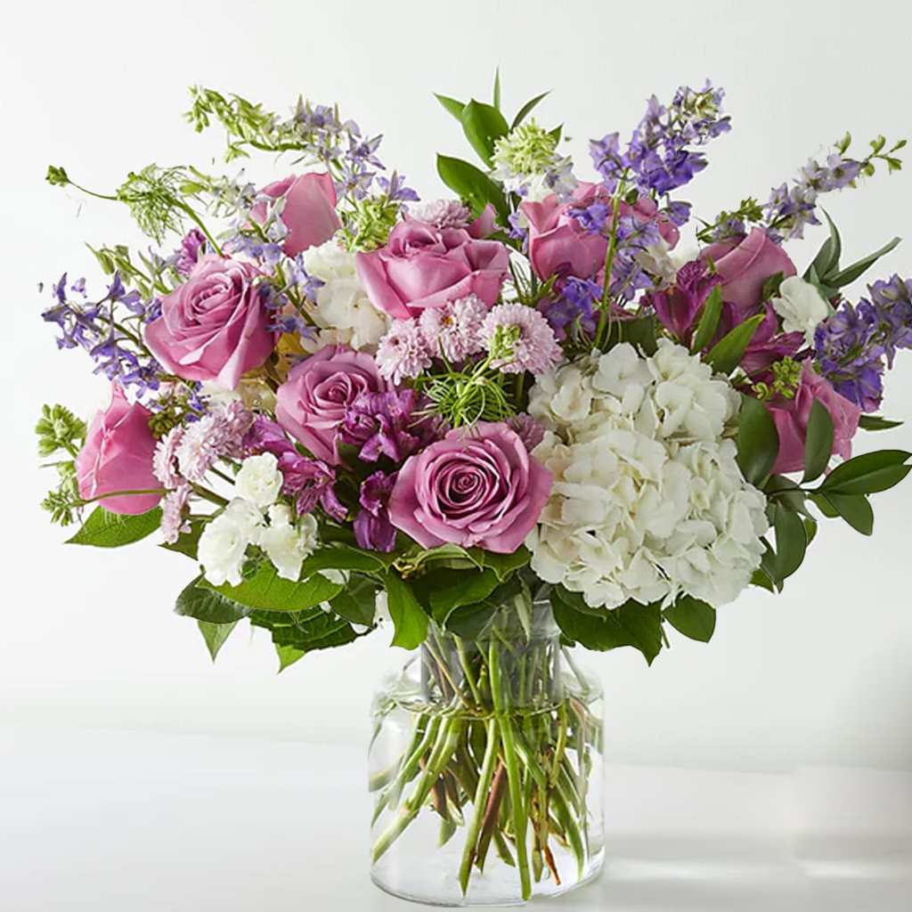 Violet Caress Violet Caress - Designed to evoke love and light, the Violet Caress Bouquet features lavender roses, white hydrangeas, purple stock, larkspur, and delicate seasonal accents. It's perfect for birthdays, anniversaries, or simply brightening someone’s day. Approximately 15" H x 15" W. Enjoy long-lasting beauty with this thoughtful gift.