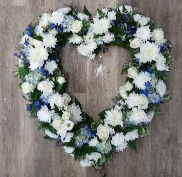Heartfelt Serenity - A tender tribute to a life well-loved, Heartfelt Serenity is a heart-shaped sympathy arrangement designed to bring comfort and peace. Featuring a graceful blend of soft white blooms and serene blue flowers, this piece symbolizes purity, tranquility, and enduring love. Ideal for expressing condolences, it speaks volumes when words fall short—offering a gentle reminder of cherished memories and everlasting connection.