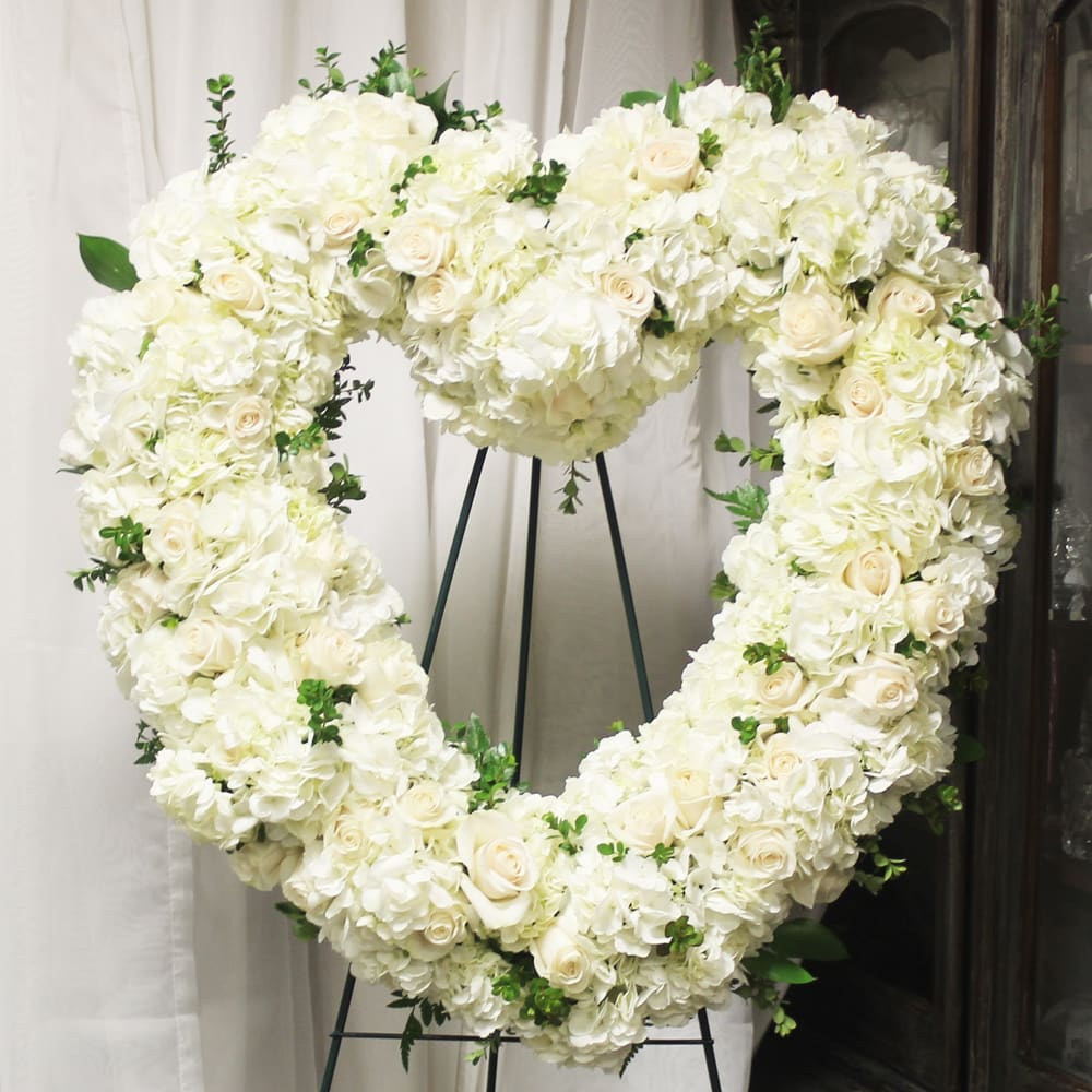 Timeless Love - A heart-shaped wreath to represent a pure love.   Key notes for this design are a wreath and an easel. If you would like to specify a color scheme, please leave us a note in the Florist Instructions field of your order when you check out.