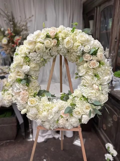 Angelic Wreath - A soft collection of white roses, hydrangea, and other premium accents to make this a full round wreath appropriate for a memorial 