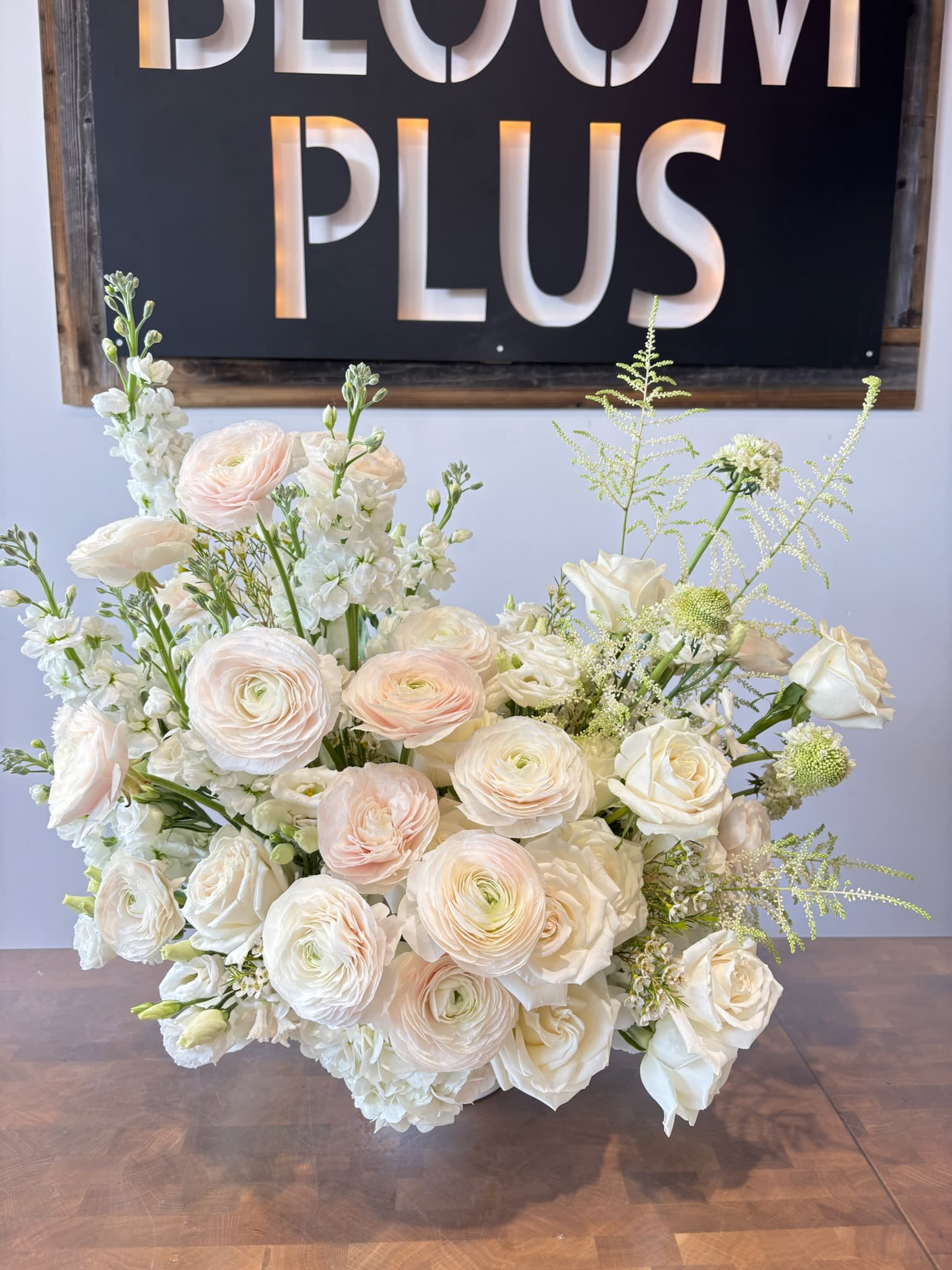 Ivory Majesty  - A grand and elegant arrangement featuring lush white and blush ranunculus, garden roses, stock, and astilbe, creating a soft, romantic look. Designed for timeless sophistication, this luxurious piece adds beauty and grace to any space or special occasion.