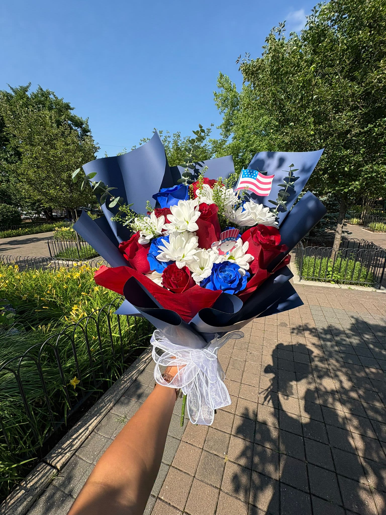 Fireworks &amp; Flowers - An explosion of color and elegance to celebrate with pride. This vibrant bouquet combines 12 roses—6 red and 6 blue—wrapped in navy blue or white paper.