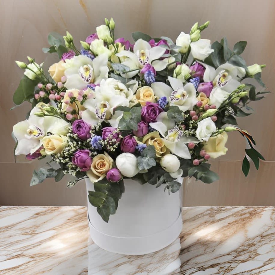 Vibrant Garden Arrangement - Los Angeles - This exquisite arrangement features a lush mix of premium flowers in a vibrant palette of purples, pinks, and soft pastels. Artfully composed in a box, the bouquet combines a variety of seasonal blooms, offering a charming garden-style look. Perfect for brightening up any space, it creates a captivating and cheerful statement piece that radiates freshness and elegance. This arrangement is ideal for birthdays, celebrations, or simply as a unique gift to express your appreciation and love.  Available for same-day delivery across Los Angeles. Make every occasion unforgettable with our handcrafted floral designs.
