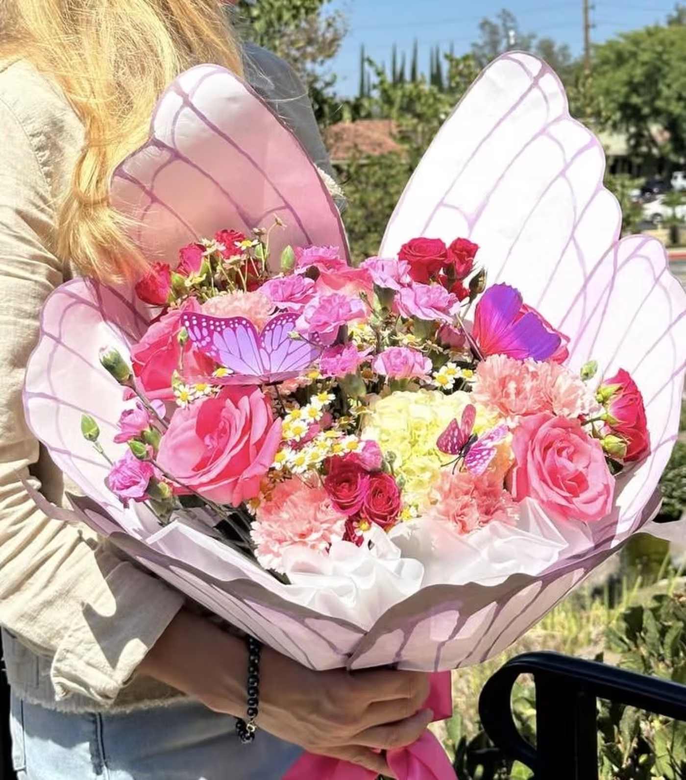 Flowers Butterfy Embrace  - Bring a touch of magic to any occasion with our stunning bouquet of pink roses, hydrangeas, and delicate accent flowers, beautifully arranged and wrapped in an elegant, wing-inspired design. This unique floral arrangement is perfect for birthdays, anniversaries, or simply to show someone you care. Our flower bouquet combines vibrant pink and soft pastel tones, creating a romantic and memorable gift. With flower delivery available throughout Los Angeles, it’s easy to surprise loved ones with this eye-catching and whimsical bouquet. Order now to enjoy the charm of premium pink roses, lush hydrangeas, and elegant florals with exclusive delivery service in Los Angeles.