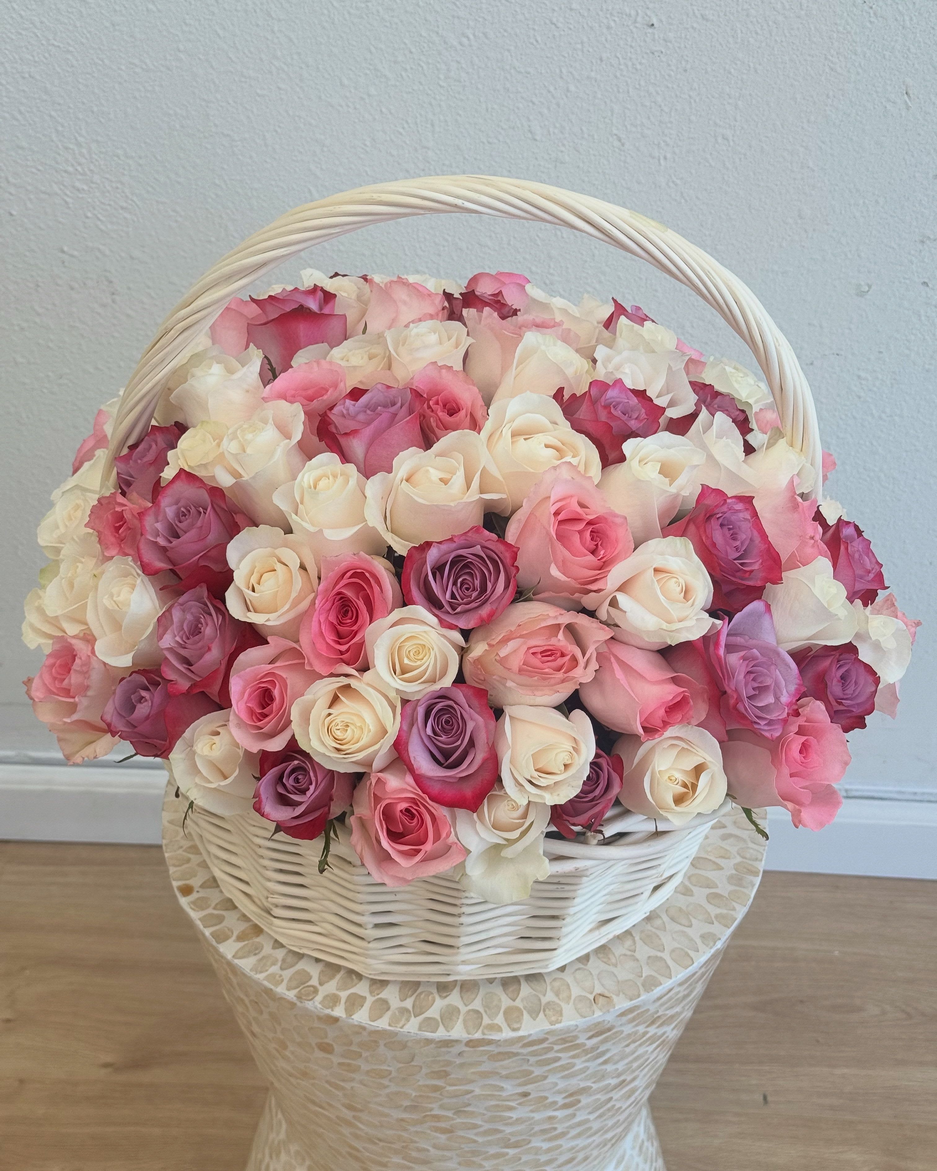 Rose Harmony Basket - Overflowing with grace and color, this stunning floral basket is a celebration of timeless romance. Featuring an exquisite blend of cream, blush pink, lavender, this arrangement is designed to make a lasting impression. Each rose variety brings its own character to the mix, creating a rich, layered look that’s both elegant and full of emotion.  Arranged in a charming white woven basket, this design is perfect for gifting on Mother’s Day, anniversaries, birthdays, bridal showers, or any moment when words aren’t quite enough. The soft, pastel palette is balanced by deeper rose tones, giving it a refined but passionate feel—ideal for both heartfelt gestures and grand celebrations.  Whether you’re expressing gratitude, love, or admiration, this rose basket is a beautiful way to do it with elegance and warmth. Available for same-day delivery in Los Angeles, it's a perfect gift for those who appreciate classic beauty with a modern twist.