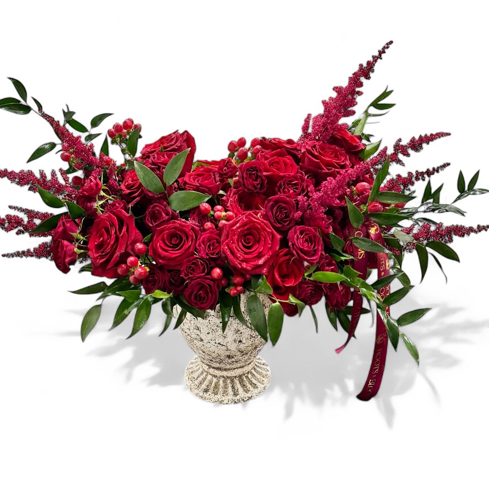 Red Affair - Bold, flirty, and impossible to ignore. Red affair is bursting with passionate red roses, dancing burgundy astible, and cheeky, red berries. Styled in a rustic stone urn, it’s a little dramatic, a little romantic, and all kind of fabulous.
