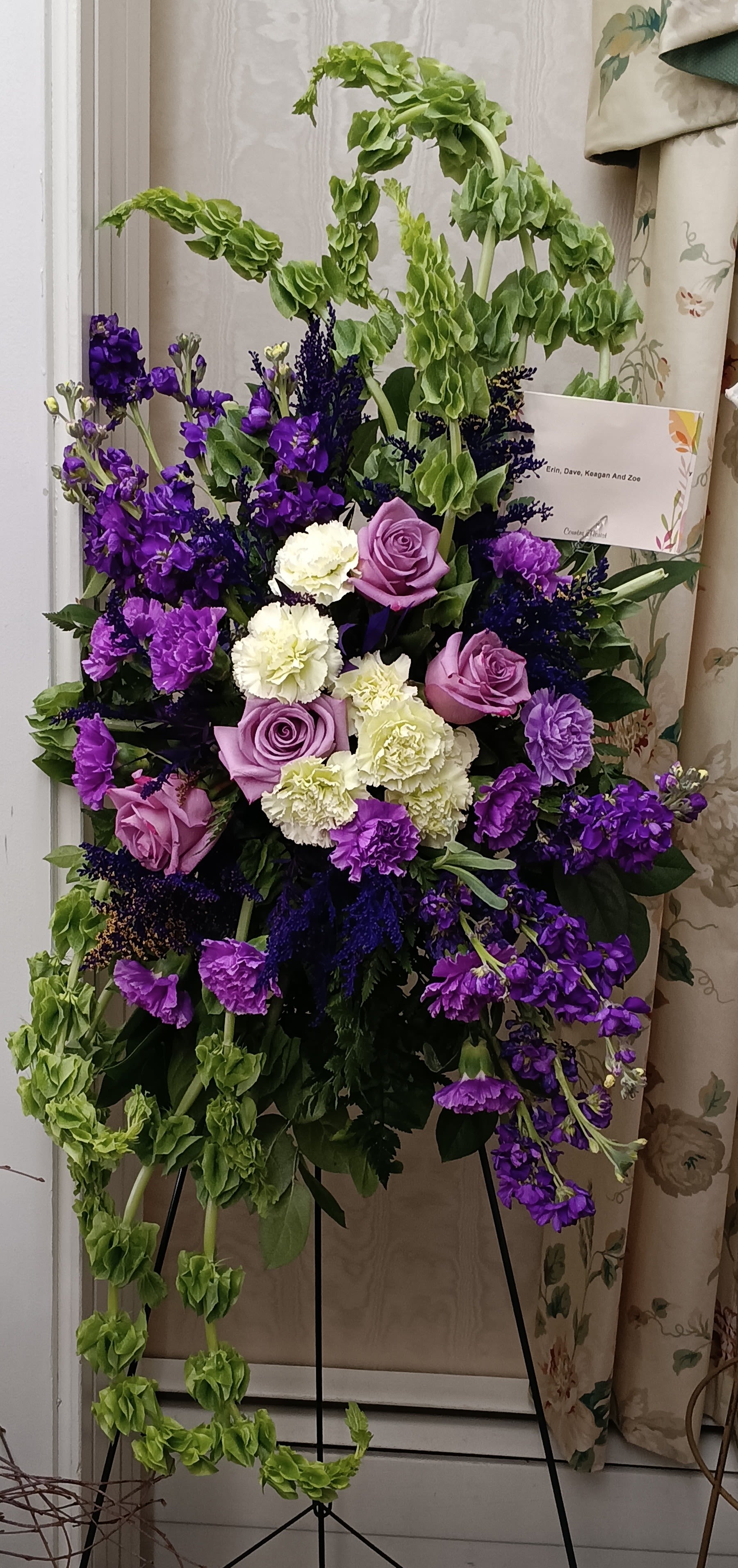 Purple Majesty Standing Spray Purple Majesty Standing Spray - A regal and elegant tribute, the Purple Majesty Standing Spray features a stunning arrangement of fresh blooms in rich purple tones, symbolizing dignity, admiration, and everlasting love. This design can be fully customized, including the flower selection, colors, and script, to create a heartfelt tribute that best honors your loved one’s memory. Our expert designer will create this standing spray using the freshest and most available flowers in the shop, ensuring a stunning and beautiful arrangement. With full creative control, they will craft a one-of-a-kind tribute that is both meaningful and breathtaking. If you are placing an order online and would like this arrangement in a specific color, please call our shop directly to ensure we can accommodate your request: 607-687-1950