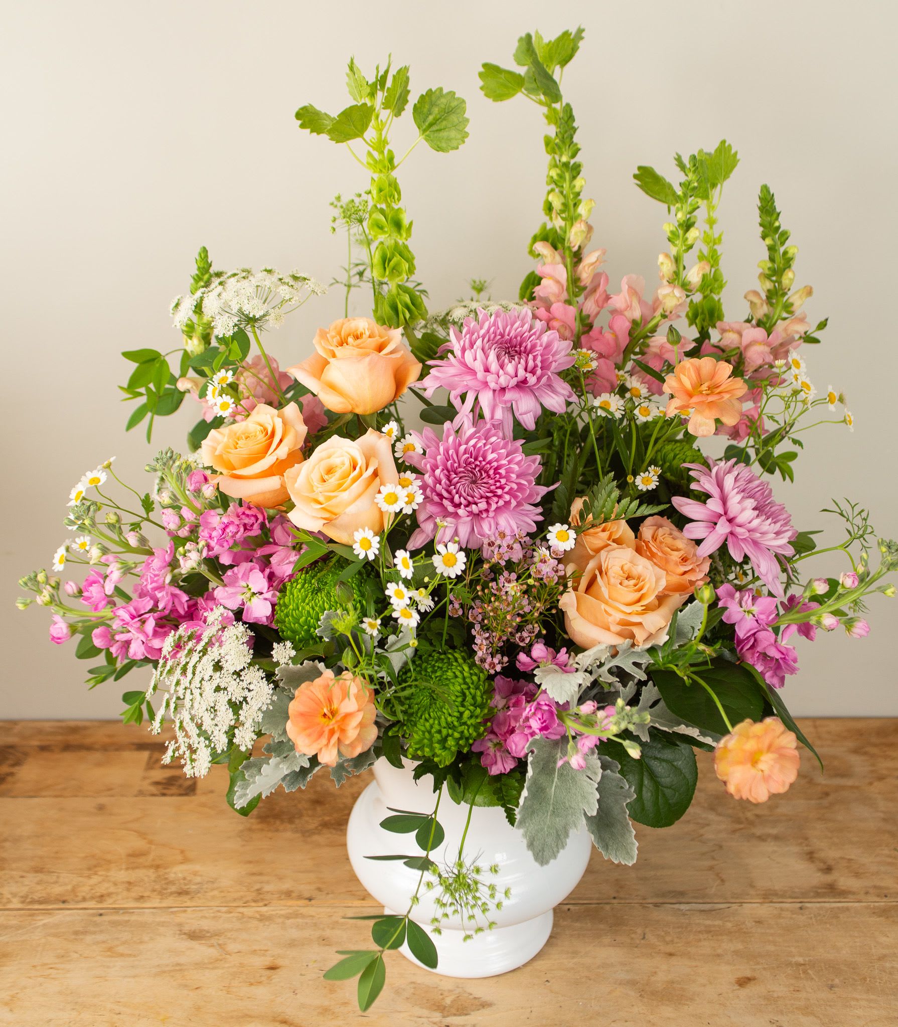 Grand Pastel - Lush, romantic, and full of charm, this arrangement showcases the very best of the season’s pastel blossoms. Featuring elegant roses, airy mums, and hand-selected seasonal favorites, it’s a soft and graceful statement in full bloom.  Approx 22&quot; x 23&quot;