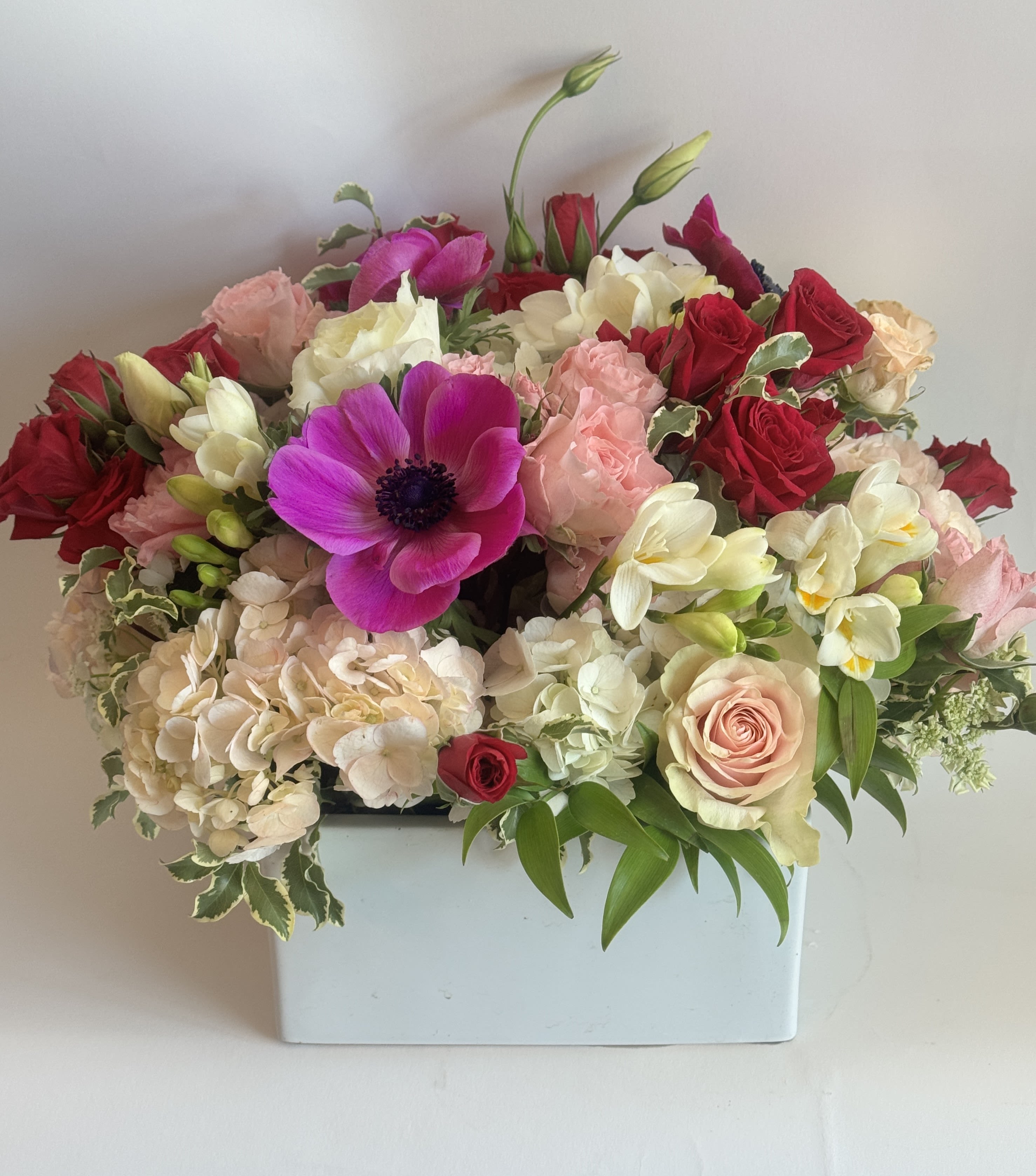 XOXO - A sweet arrangement with anemones, roses, lisianthus, and hydrangea. 