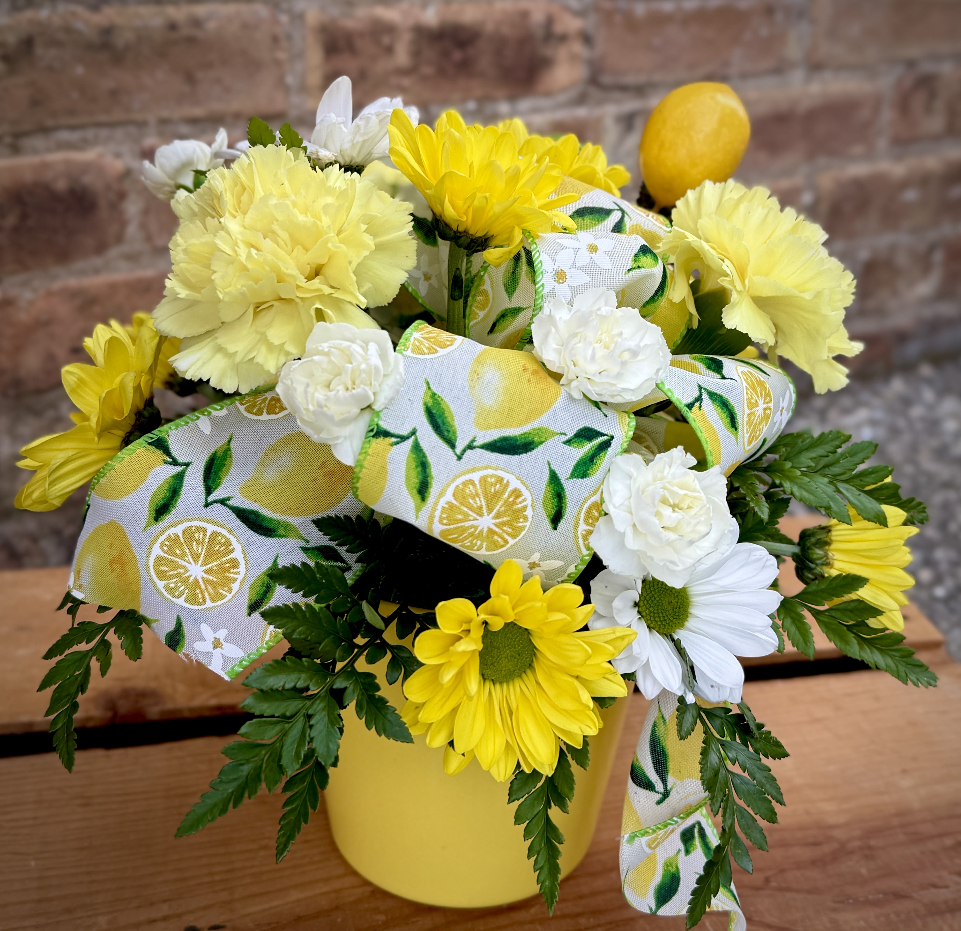 Lemon Dream Lemon Dream - Summer! Lemonade! Refreshing! This lovely arrangement makes you think of all of these! Yellow and white flowers with lemon themed trim. We are proud to deliver our flower creations to the Kenosha, Somers, and Pleasant Prairie areas. With over 55 years of combined flower design experience in Kenosha, Wisconsin, A Summer's Garden Florist and Gifts is the perfect choice for the freshest flowers, most creative design, and exceptional customer service.