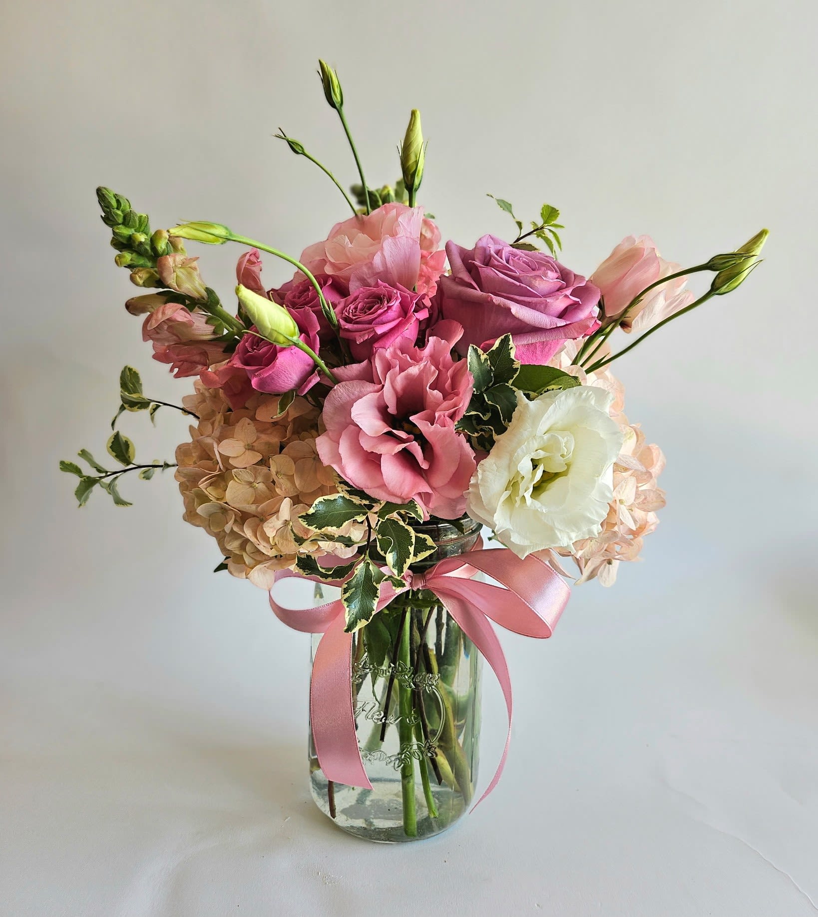 Sweet Whisper - A stunning pink and lavender floral arrangement brimming with elegance and softness. Featuring lush roses, voluminous hydrangeas, and delicate lisianthus, this bouquet captures the full spectrum of pink. 