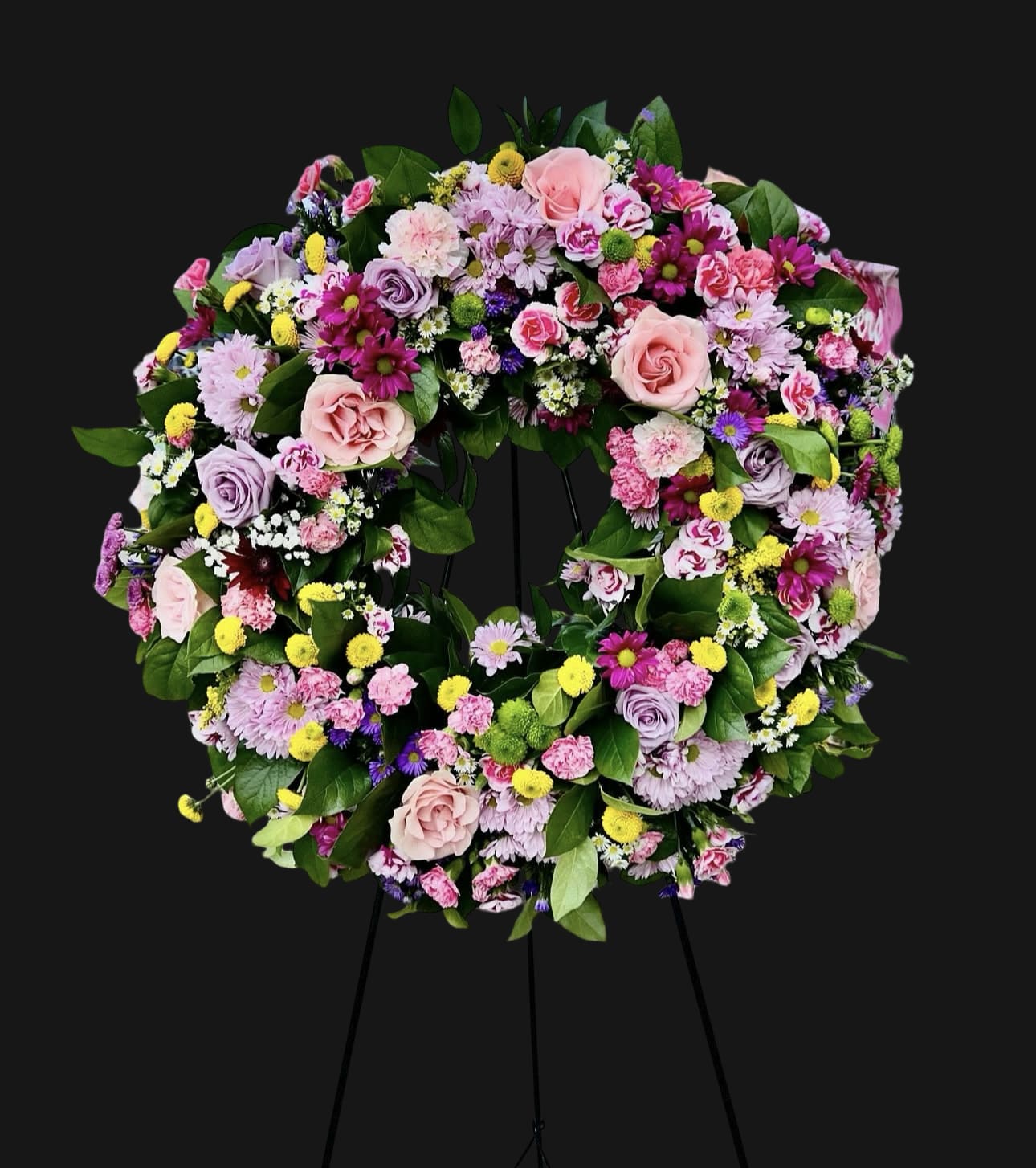 Eternal Garden Wreath Eternal Garden Wreath - This lush sympathy wreath features an elegant blend of roses, lisianthus, chrysanthemums, carnations, and daisy poms in shades of pink, lavender, yellow, and white — ideal for memorials or funerals.
