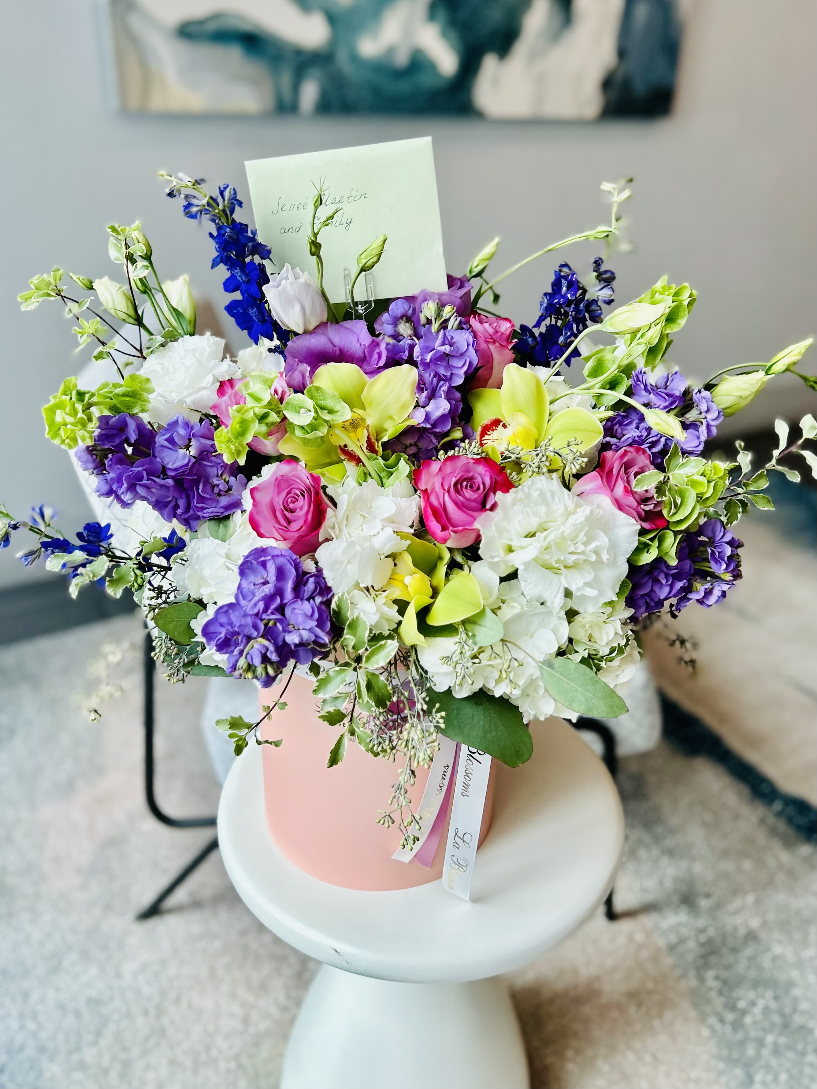 English garden - This bouquet is a beautiful blend of vibrant colors and delicate flowers, perfect for adding elegance and charm to any occasion. With lush pink roses, white hydrangeas, purple lisianthus, and hints of green orchids, this arrangement brings together freshness and sophistication in a soft pink hatbox. Ideal for gifting or as a centerpiece, it radiates joy and warmth.