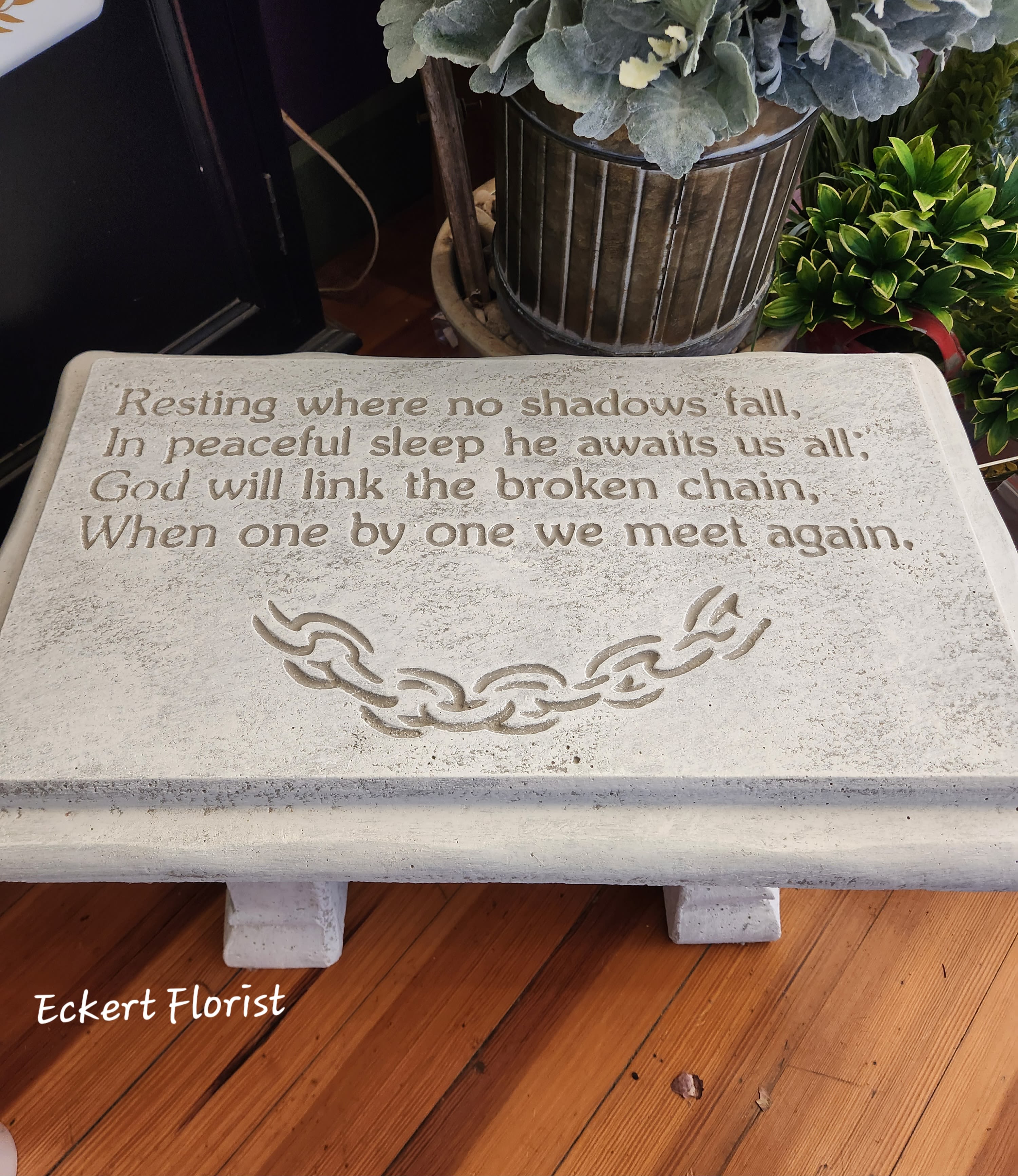 Eckert Florist's "Resting..." Stone Bench *Our Local Delivery Only Eckert Florist's "Resting..." Stone Bench *Our Local Delivery Only - Stone Garden Bench. Sentiment: "Resting where no shadows fall, In peaceful sleep he awaits us all; God will link the broken chain, When one by one we meet again." * LOCAL DELIVERY ONLY *Style of bench may vary. ALL OF OUR STONES COME DECORATED WITH A SHEER BOW, WILLOW, RAFFIA, AND OUR SIGNATURE BIRD.