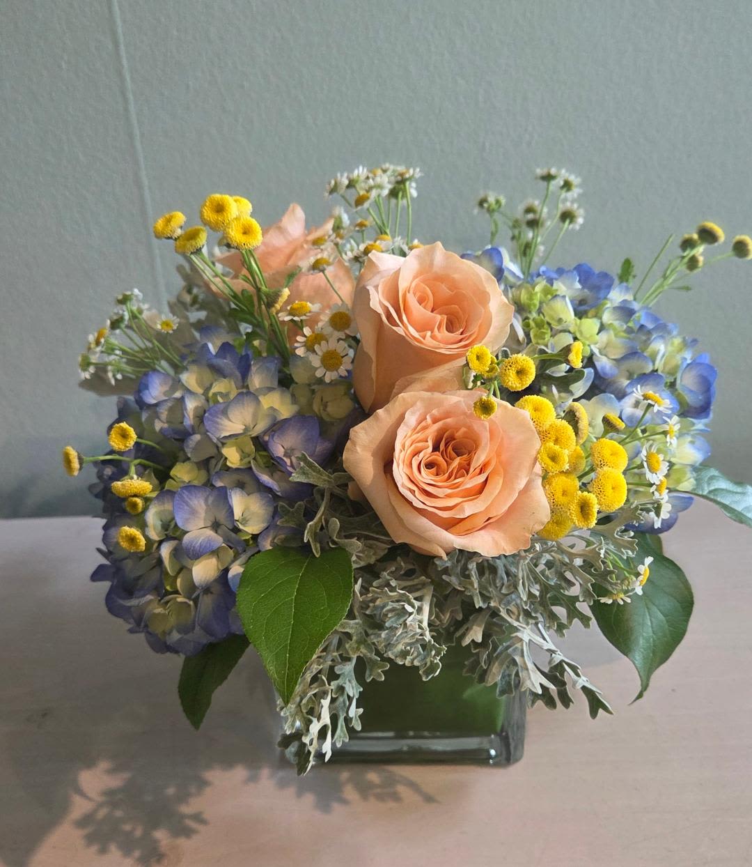 Avalon Beach Avalon Beach - Cool and Tranquil just like a beautiful day at the beach... With blue hydrangeas, peach roses, dusty miller, and accents of yellow tansy.
