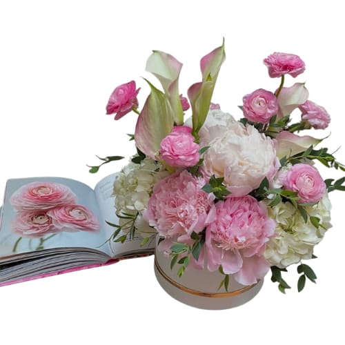 Floral Opulence - Indulge in the exquisite beauty of &quot;Floral Opulence,&quot; a lavish arrangement showcasing the most luxurious blooms of the season.  Opulent peonies, textural ranunculus, and the elegant lines of calla lilies are artfully combined with the voluminous fullness of hydrangeas, creating a sophisticated and unforgettable statement.  *Peonies subject to seasonal availability and may not be available in the fall and winter months. During that time it will be substituted with pink hydrangeas.   *book not included and for display purposes
