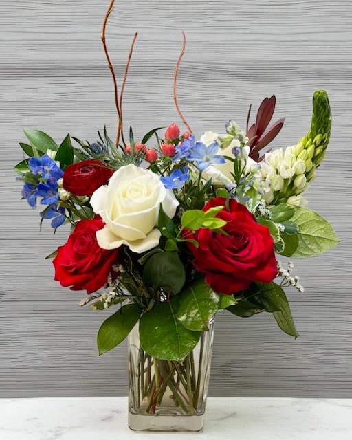 Red White &amp; Bloom - A vibrant mix of red roses, white blooms, and soft blue accents. Fresh, elegant, and perfect for any occasion.