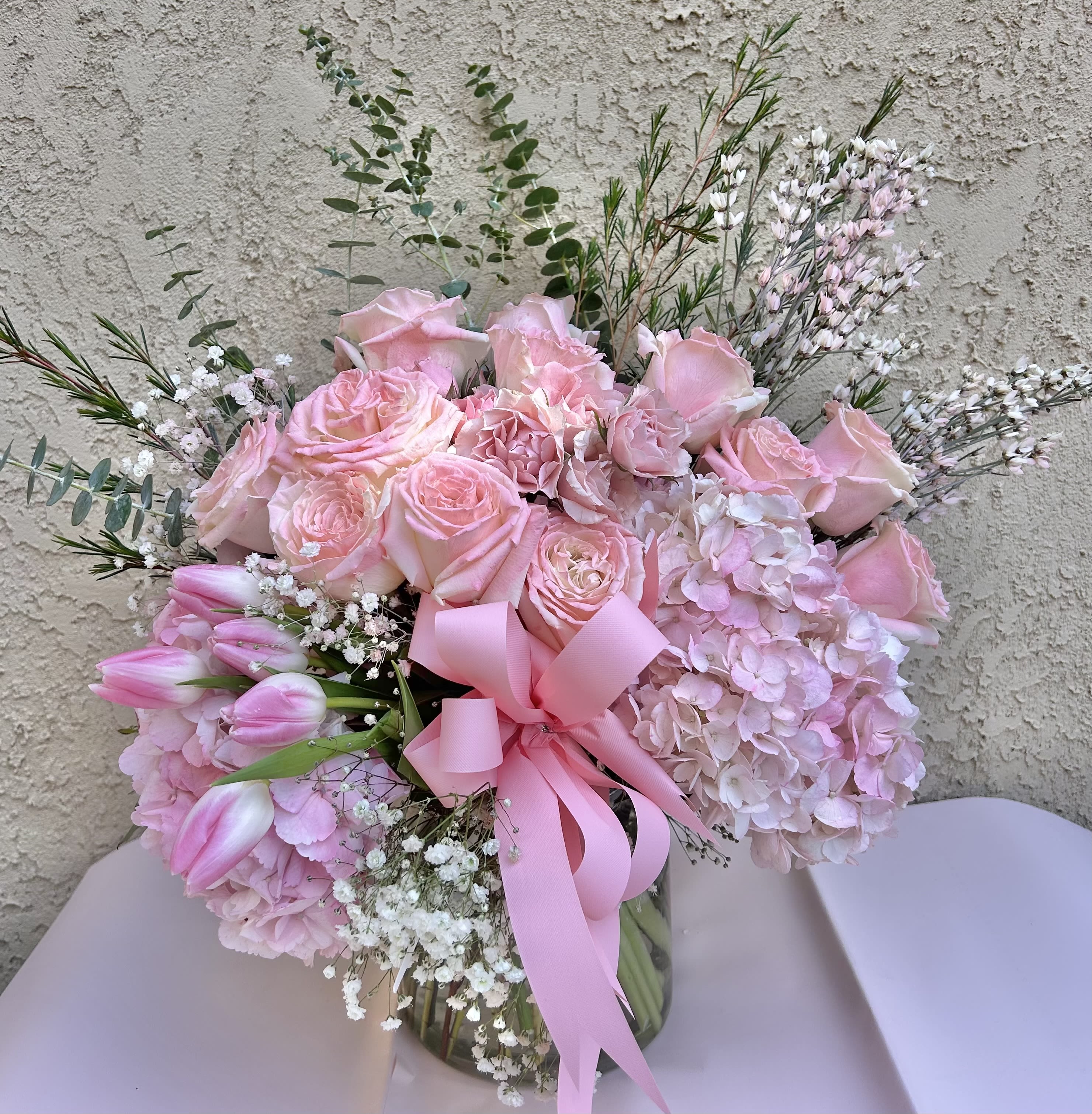 Blush - Beautiful flower arrangement featuring pink roses, pink tulips, and hydrangeas with green and white accents.