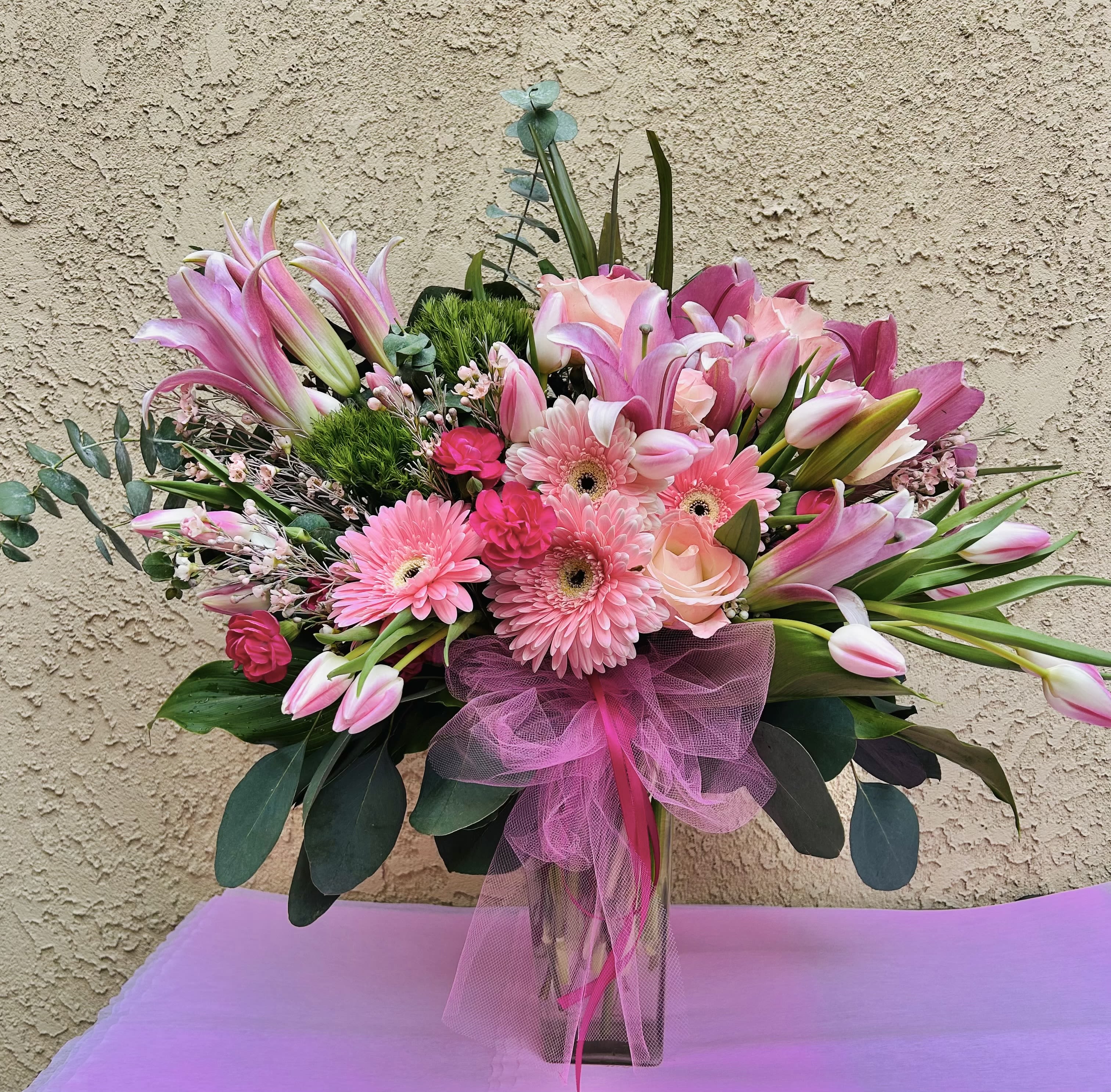 Cherry Breeze - Beautiful flower arrangement featuring pink lillies, pink tulips, pink gerbera daisies, and green accents.