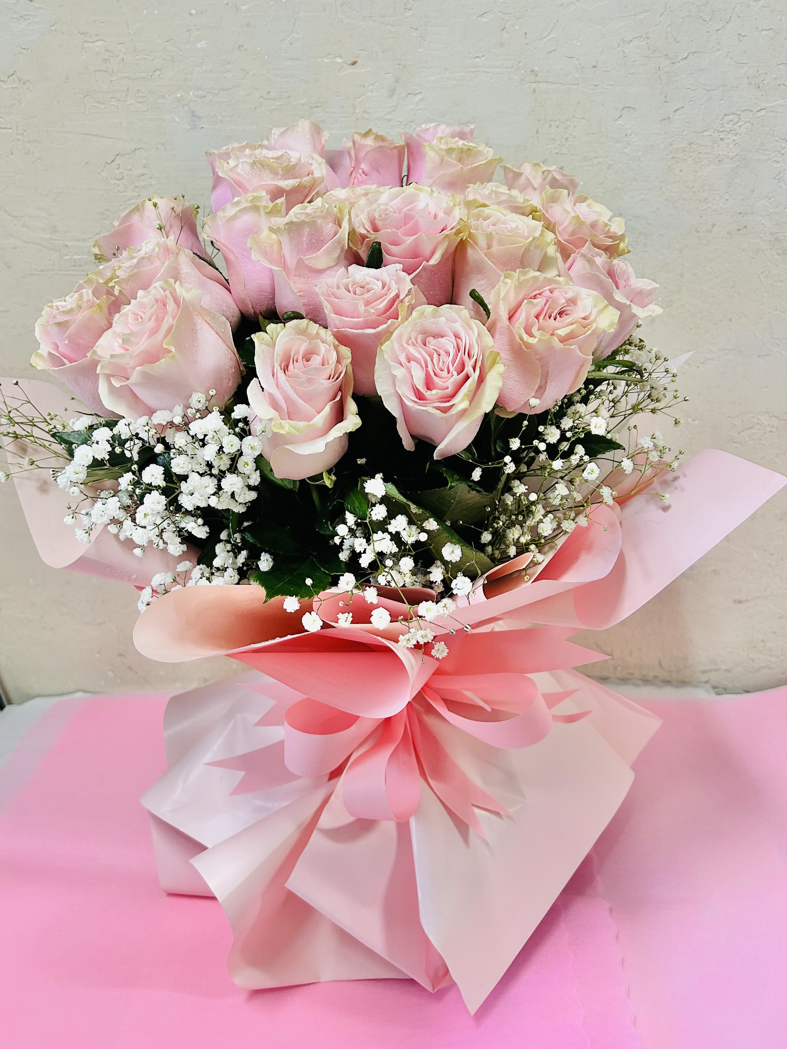 Rosé Reverie - Beautiful bouquet featuring pink roses with white and green accents, wrapped in pink lining.