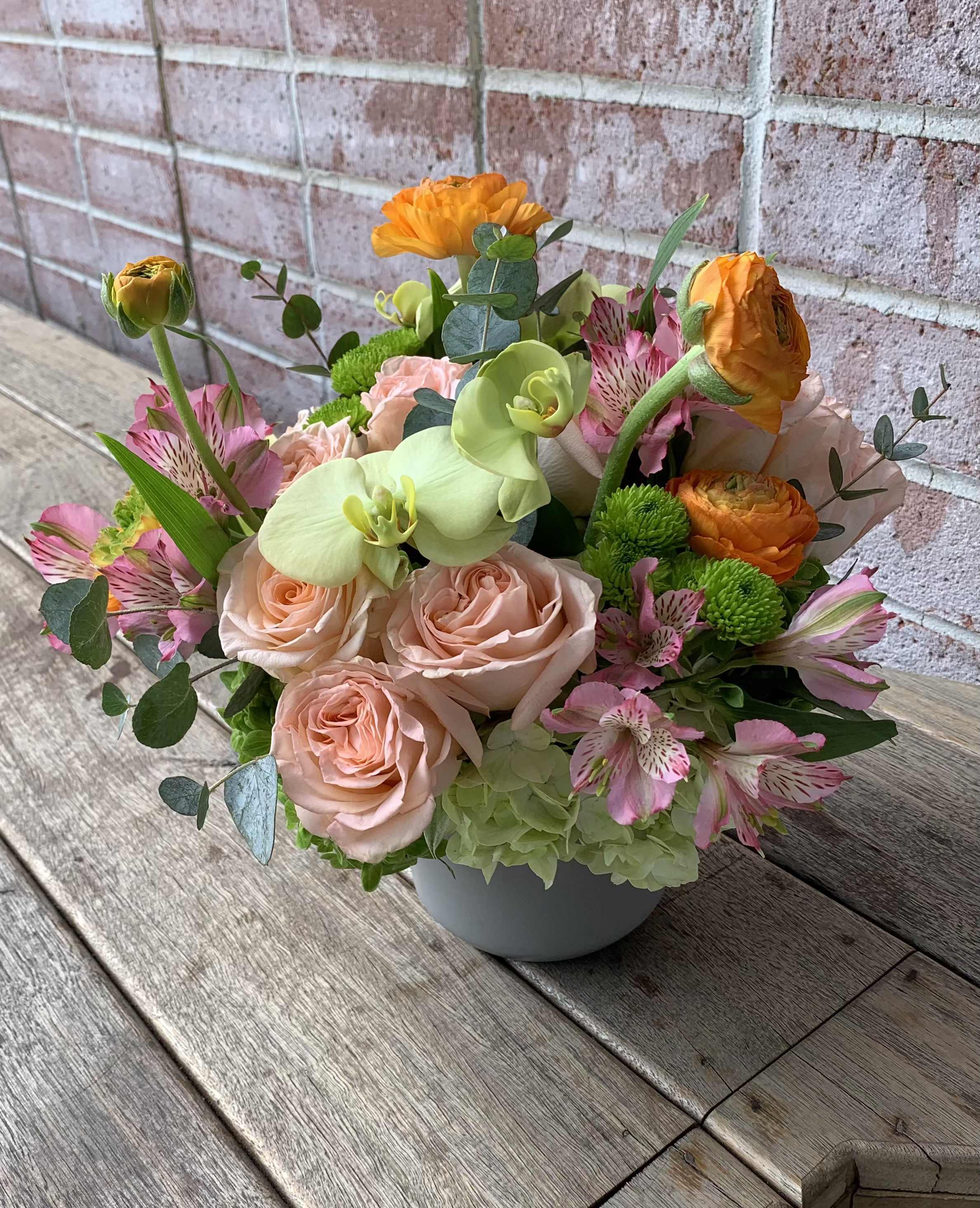 Golden Green Golden Green - Elegant flower arrangement that features peach colored roses to give it softness, orange ranunculus that add vibrance, green hydrangeas offering fresh, lively contrast, and many other flowers that make this exotic arrangement full of beauty and charm.