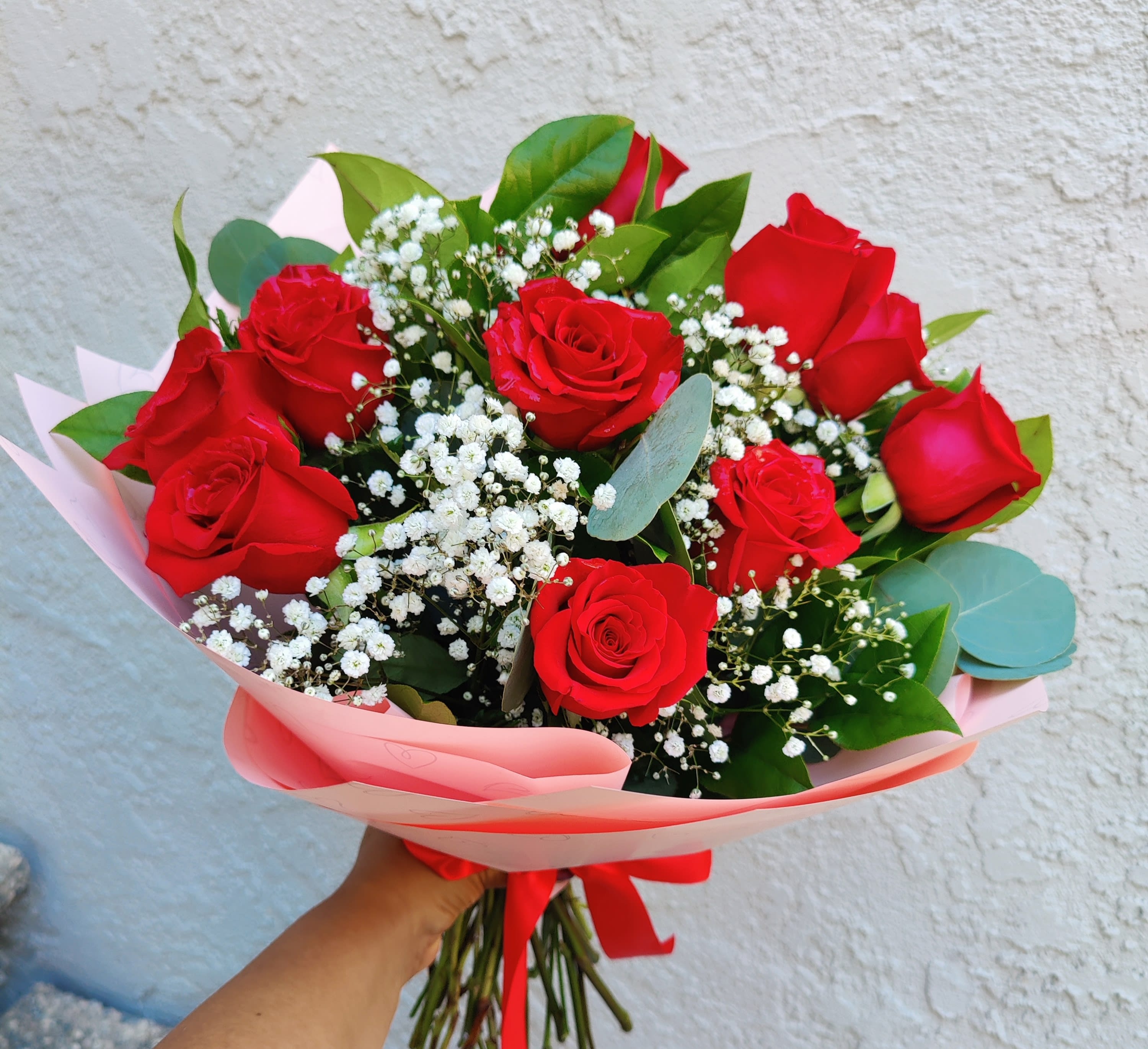 Dozen Red Roses Wrapped Bouquet - Beautiful  red rose bouquet created with 12 quality fresh roses from Ecuador. It's Accented with seasonal greens and white filler flowers.. Perfect for  a special moment. Long stem roses It has  1 dozen of red roses. No vase included.  Standard size includes 12 roses  Deluxe includes 18 roses