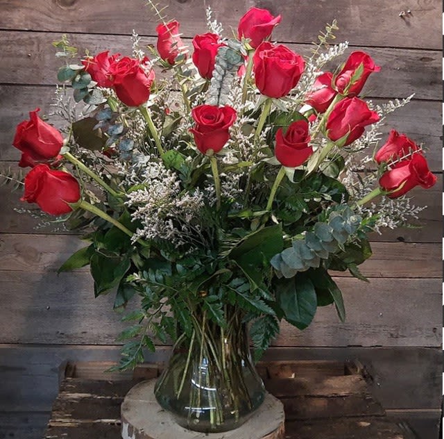 2 Dozen Long Stem Red Roses 2 Dozen Long Stem Red Roses - 2 dozen long stem red roses arranged beautifully in large glass vase with premium greens, eucalyptus, and filler. This show-stopping arrangement is the perfect ode to love for an anniversary or just because.
