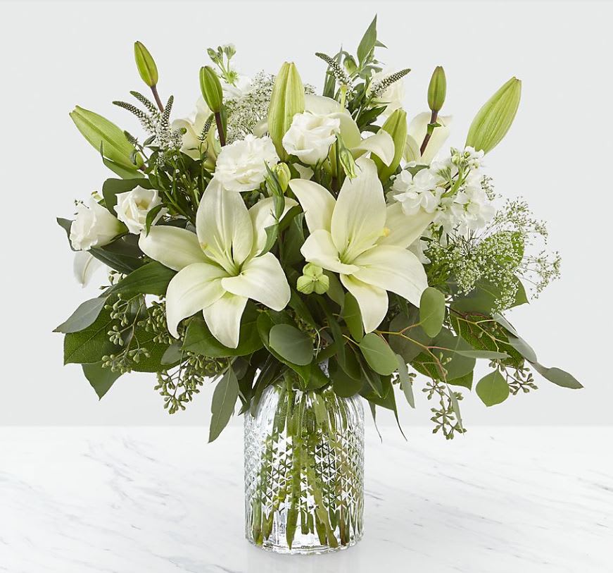 Alluring Elegance™ Bouquet - Our Alluring Elegance Bouquet is a striking array of ivory and green. Handcrafted using Asiatic lilies interwoven with white Veronica, white stock, Queen Anne's lace, silver dollar eucalyptus and seeded eucalyptus, this bouquet graces every room with a touch of elegance. GOOD bouquet is approx. 17&quot;H x 14&quot;W. BETTER bouquet is approx. 18&quot;H x 17&quot;W. BEST bouquet is approx. 19&quot;H x 18&quot;W.  