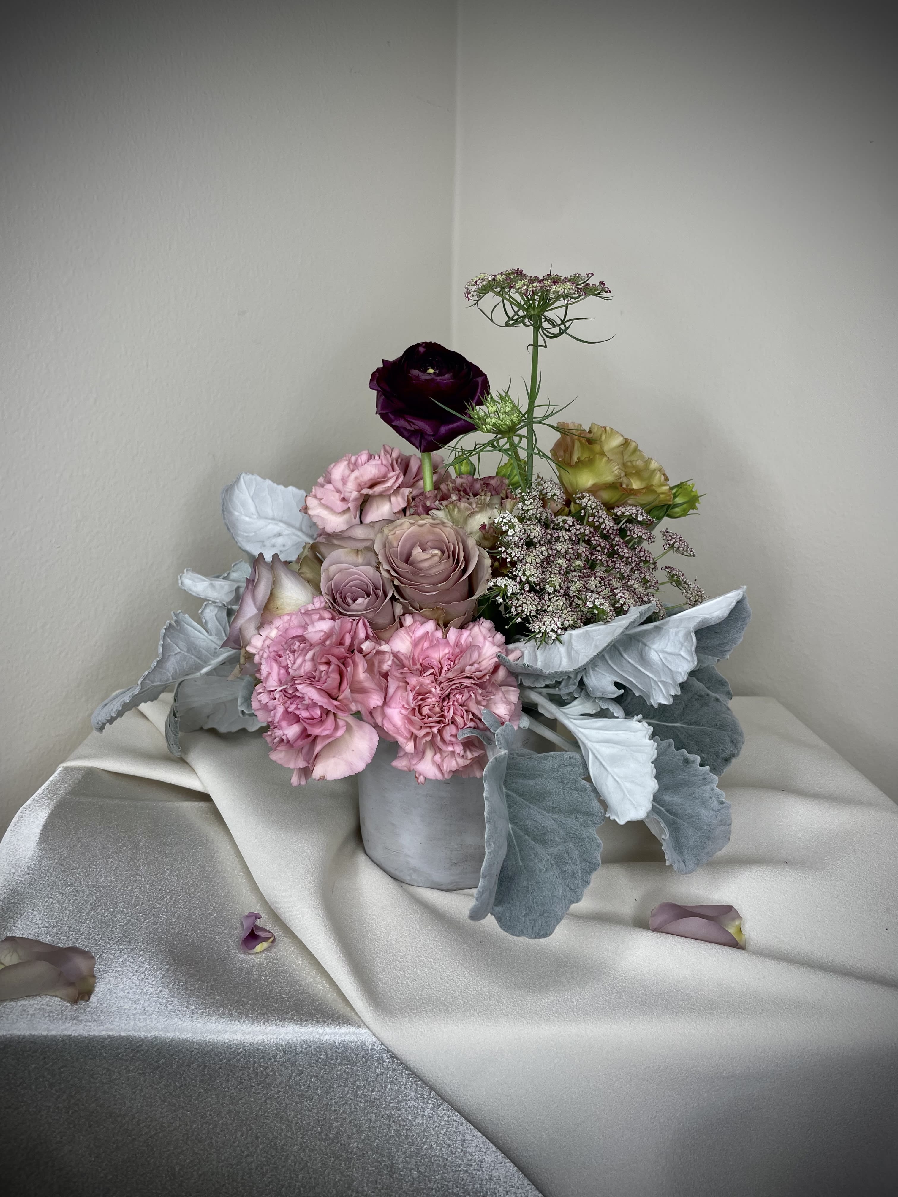 Duster - Set in a cement cylinder, our arrangement is made with the ever so elegant Dusty Miller to set as the start of an arrangement worthy of intrigue. Each flower hand picked and placed into an eco friendly vessel without the use of any floral foam. Small but mighty, the Petite Duster will fill any space with charm and beauty.    Colors of the blooms will vary according to seasonal availability.  All arrangements can be made tailored to your occasion. 
