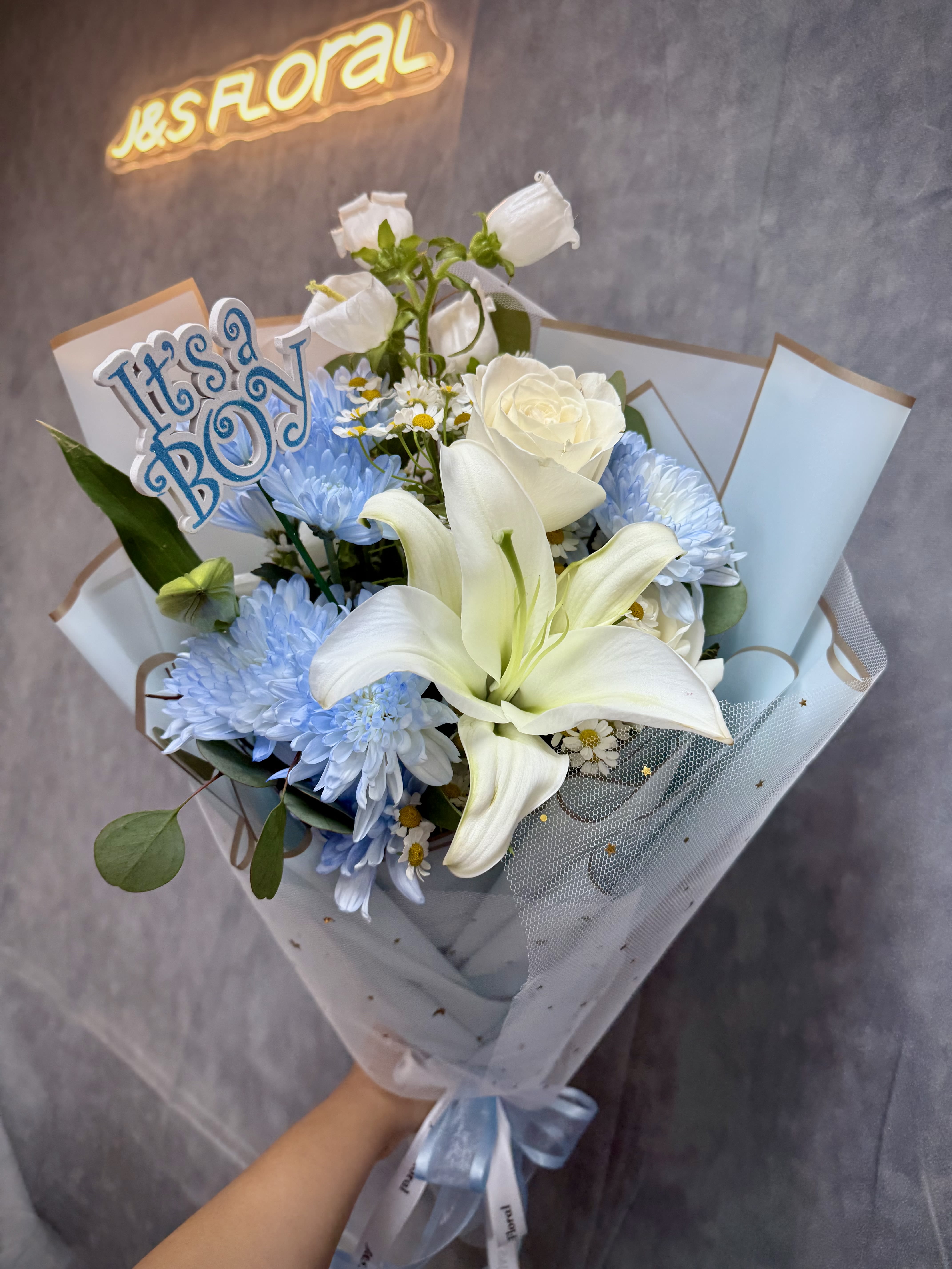 Sweet Baby Boy -  Introducing Our Sweet Baby Boy Bouquet  A soft and charming hand-tied arrangement featuring delicate white and blue blooms—perfect for welcoming a precious little one into the world. Thoughtfully designed to celebrate new beginnings with grace and joy.