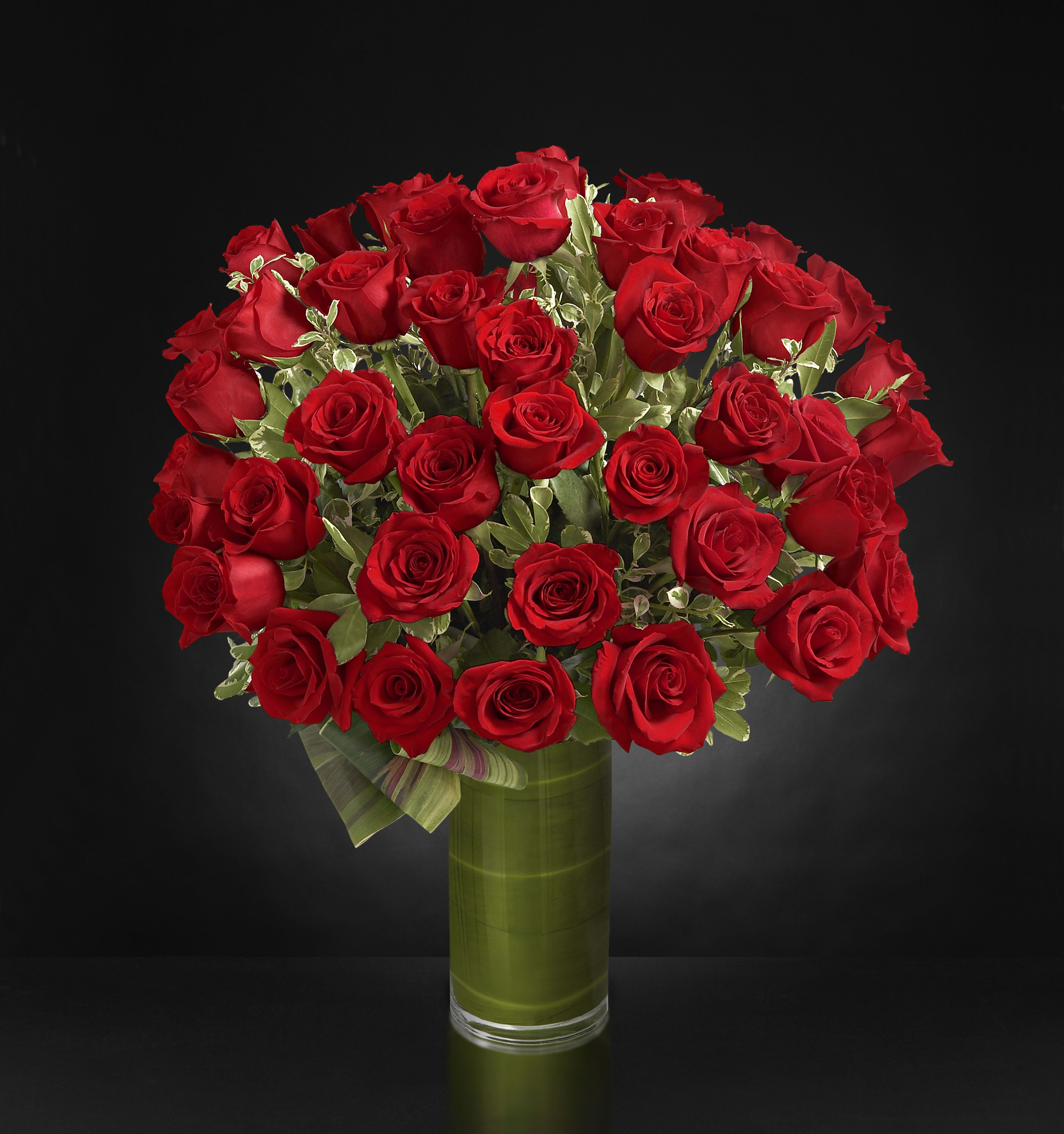 Bouquet of red roses in a tall glass vase
