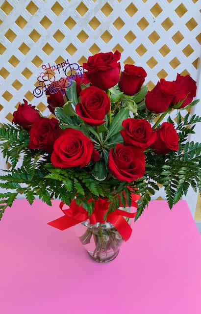 Dozen Red Roses - Where elegance meets emotion, and every petal tells a story.  Picture this: twelve hand-selected roses, each one a masterpiece of nature. Their velvety petals unfurl in perfect spirals, rich with color—whether classic crimson red, soft blush pink, radiant sunshine yellow, or pure snowy white. Nestled in lush greenery and accented with delicate baby’s breath, these roses are arranged with care and artistry by our expert florists.   Why Choose Our Dozen Roses?  Unmatched Freshness: Sourced daily from trusted growers, our roses are vibrant, fragrant, and long-lasting.  Elegant Presentation: Wrapped in premium paper or arranged in a chic vase, ready to impress from the moment they arrive.  Timeless Symbolism: A dozen roses say “I love you,” “I’m thinking of you,” or “You’re extraordinary” without a single word.  Locally Crafted with Love: Supporting our flower shop means supporting a small business that puts heart into every bouquet.   Perfect For:  Anniversaries, birthdays, or just-because moments  Romantic gestures that leave a lasting impression  Elevating any space with natural beauty and fragrance   Make it More Than a Gift—Make it a Moment. When you send a dozen roses from our shop, you’re not just giving flowers. You’re delivering joy, beauty, and a memory that blooms long after the bouquet is received.  Ready to make someone’s heart skip a beat? Let these roses do the talking.